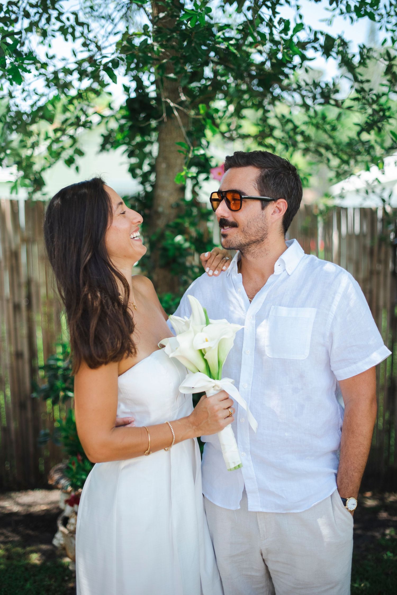 Couple shares laughter and intimate moments during outdoor garden celebration.
