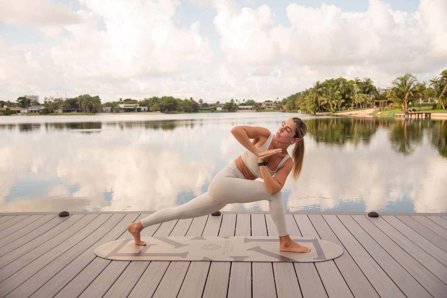Yoga flow sequence photographed on waterfront deck with cloudy sky.