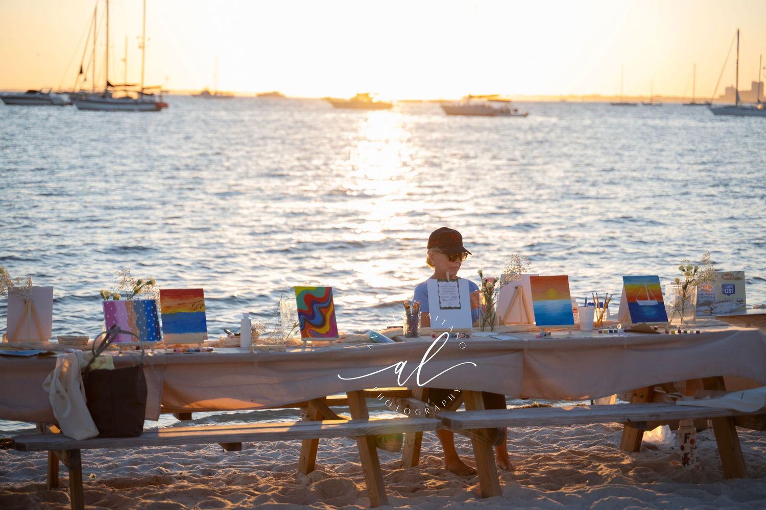 Beach chairs lined up at sunset with boats in the harbor create a peaceful coastal scene.