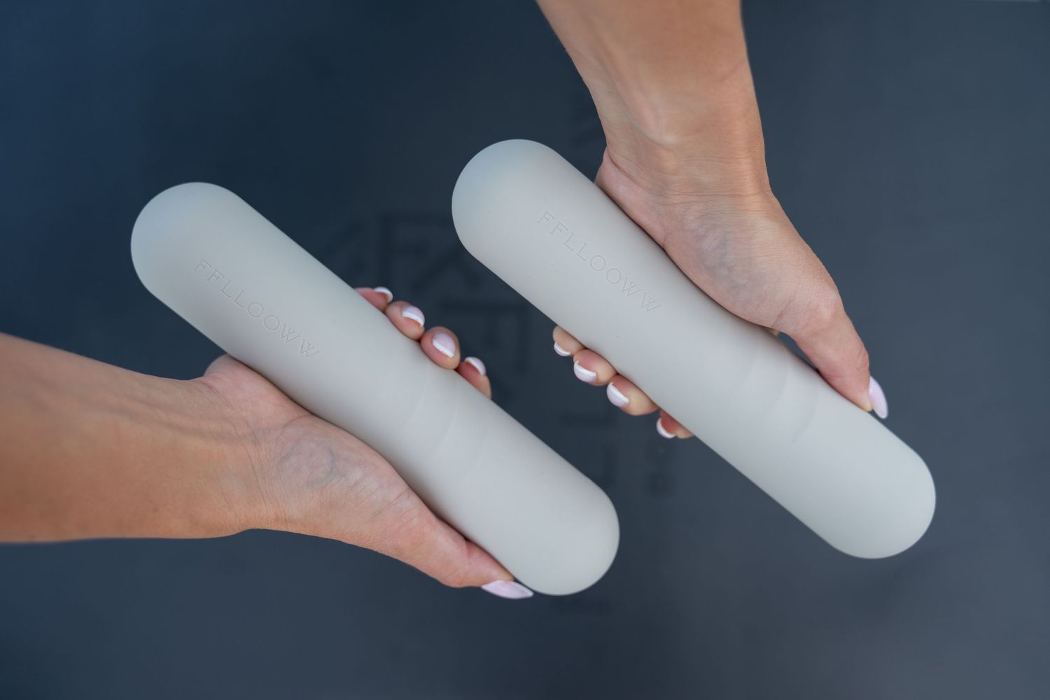 Close-up shots of hands holding cylindrical exercise equipment in sequence.