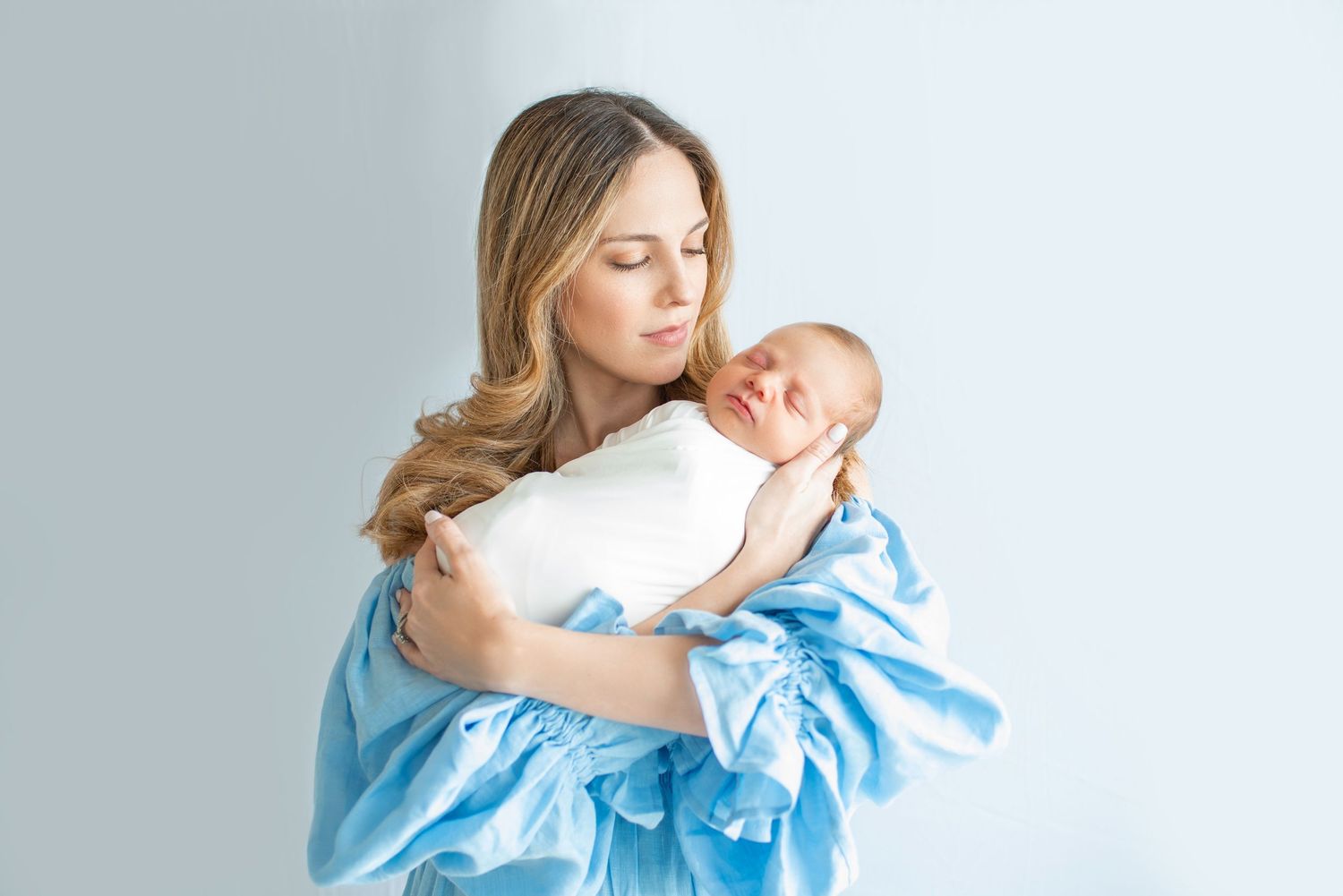 Intimate family moment in soft blue and white tones.