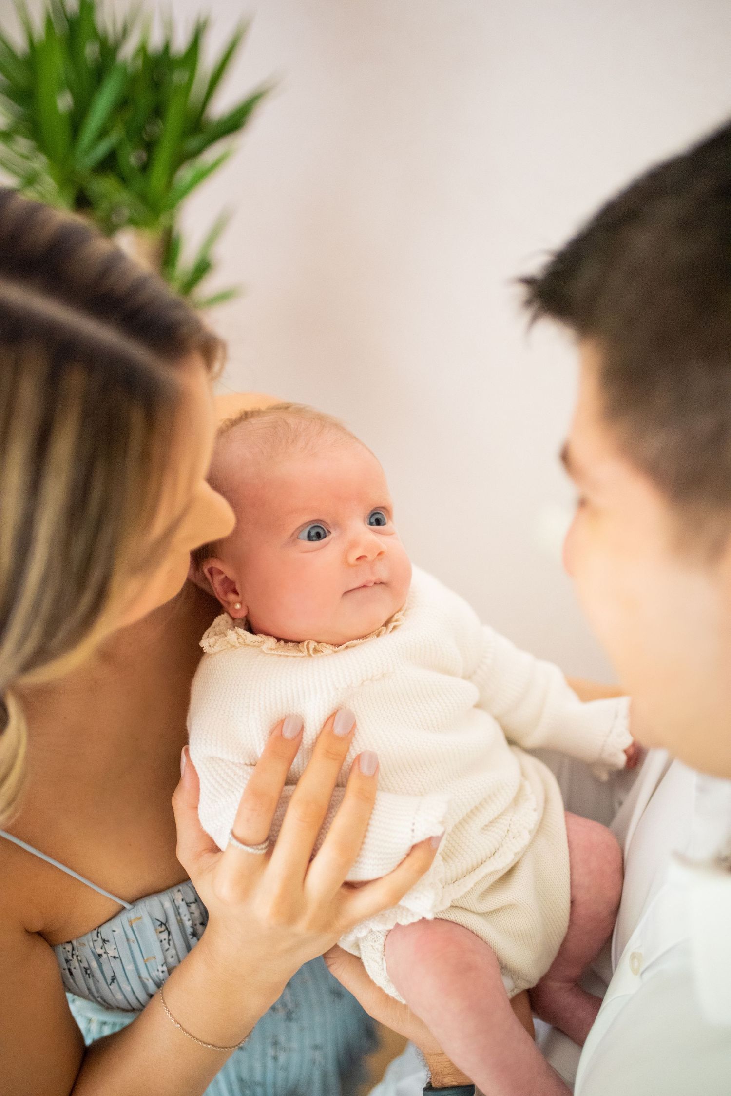 Parents lovingly hold and gaze at their newborn baby in a tender sequence of photos.