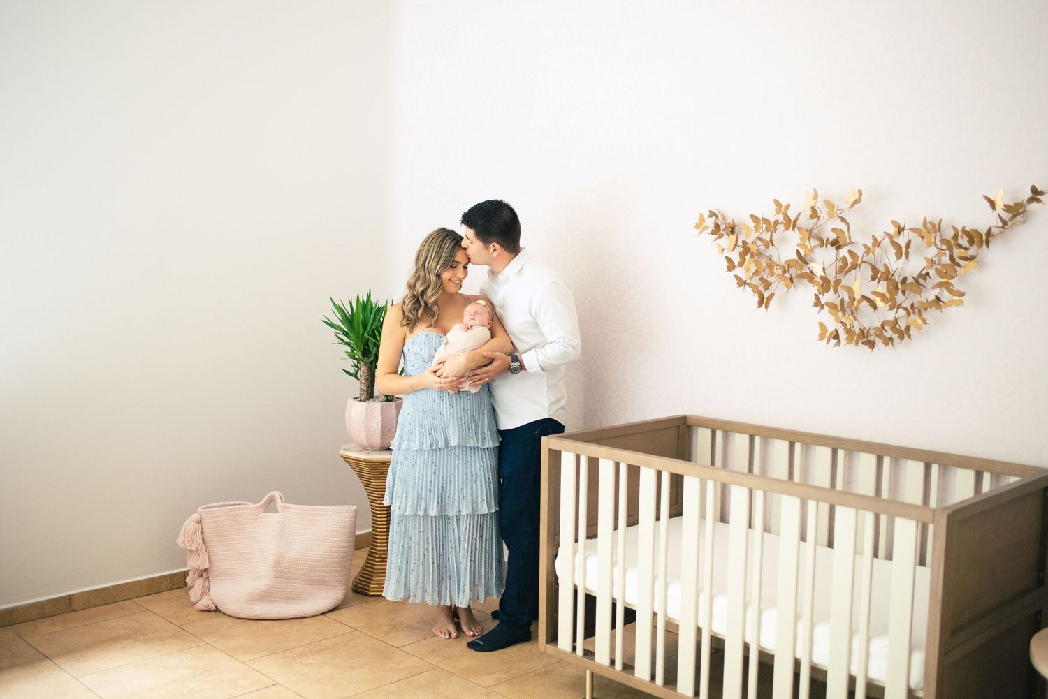 A series of tender nursery moments showing parents with a newborn baby in a white crib and natural decor.