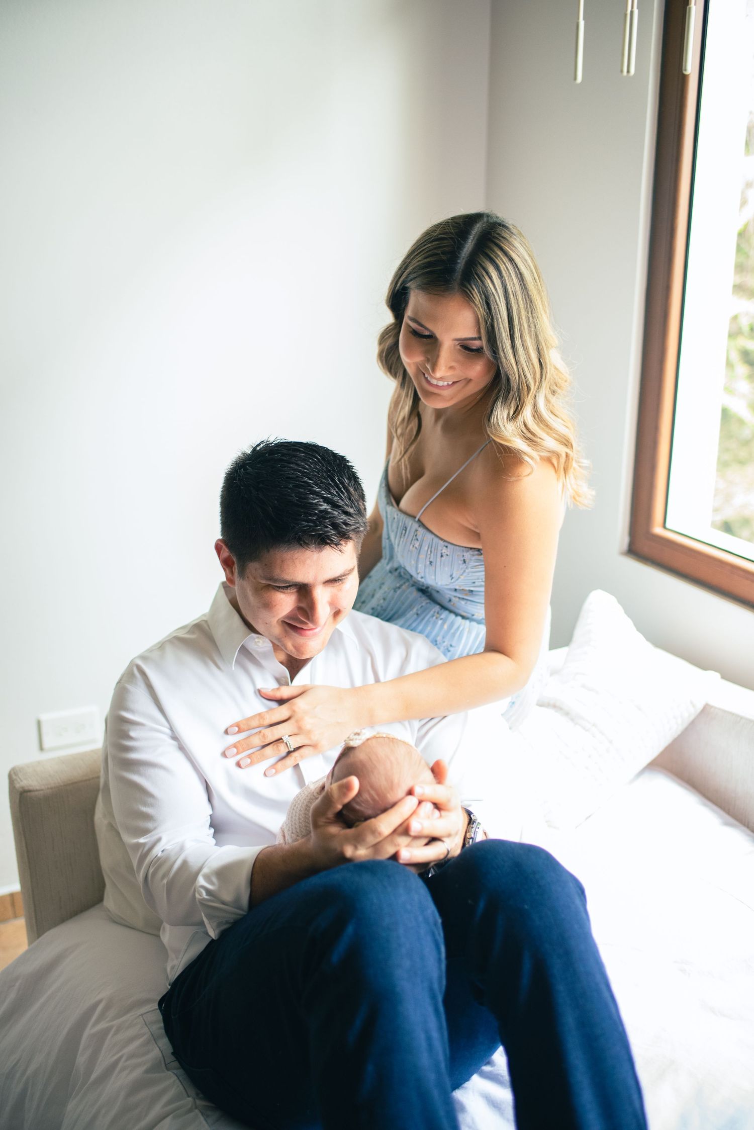 Intimate lifestyle photo series showing a couple in white and blue casual attire sitting together by a window.