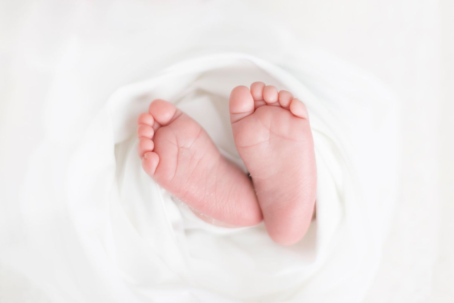 Three close-up photos of tiny newborn baby feet against a white background.