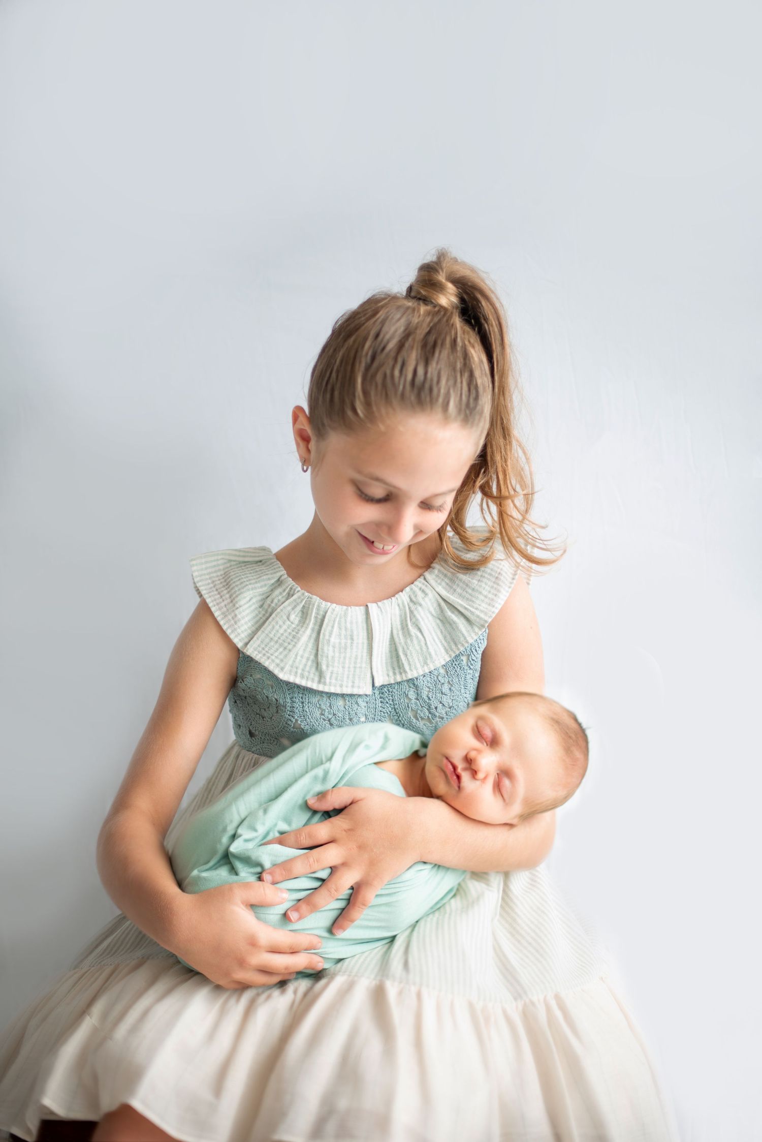 Sweet portrait of siblings in mint and white dresses sharing a special moment together.