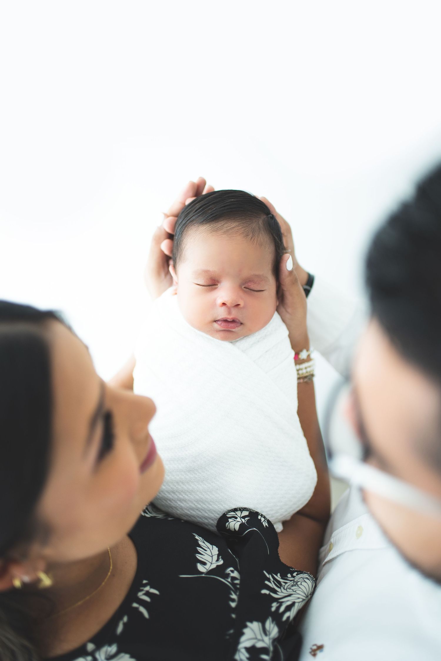 A tender moment of a baby being held against a white background.
