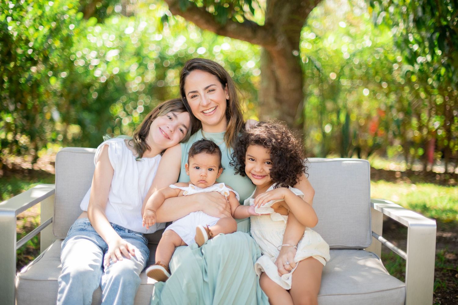 Family members share tender moments together while relaxing outdoors in a garden setting.
