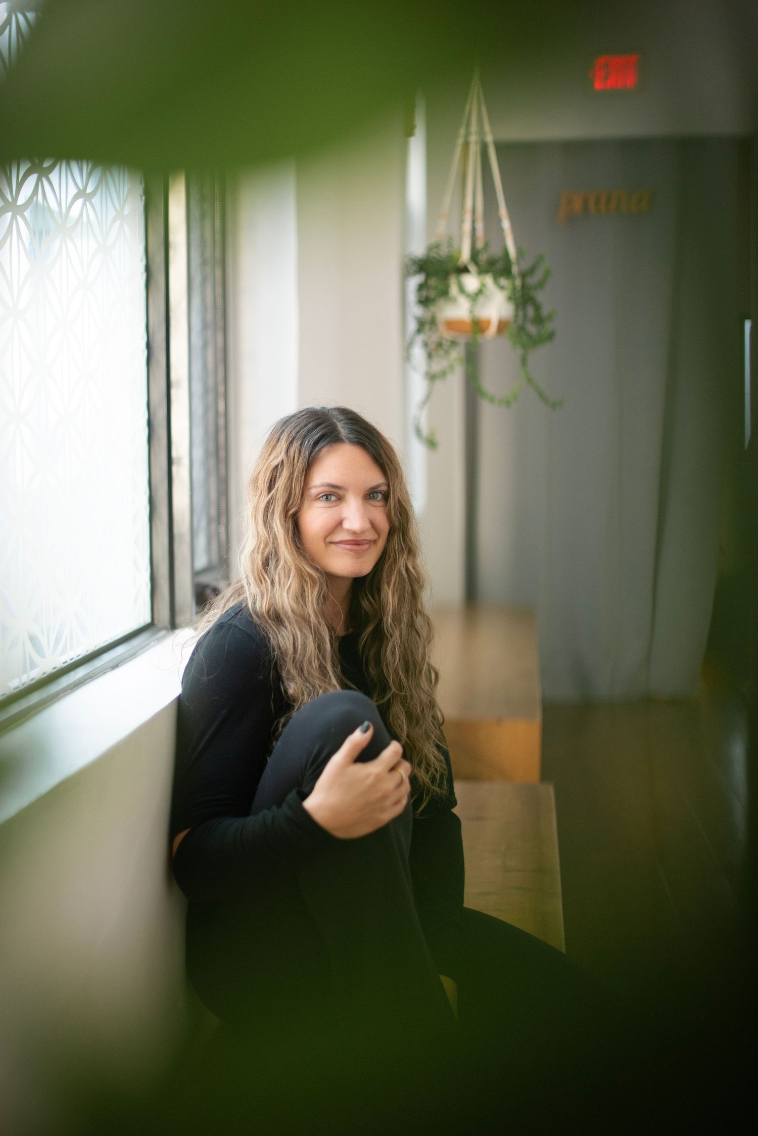 Indoor portrait sequence showing a person in dark clothing near windows with soft lighting.