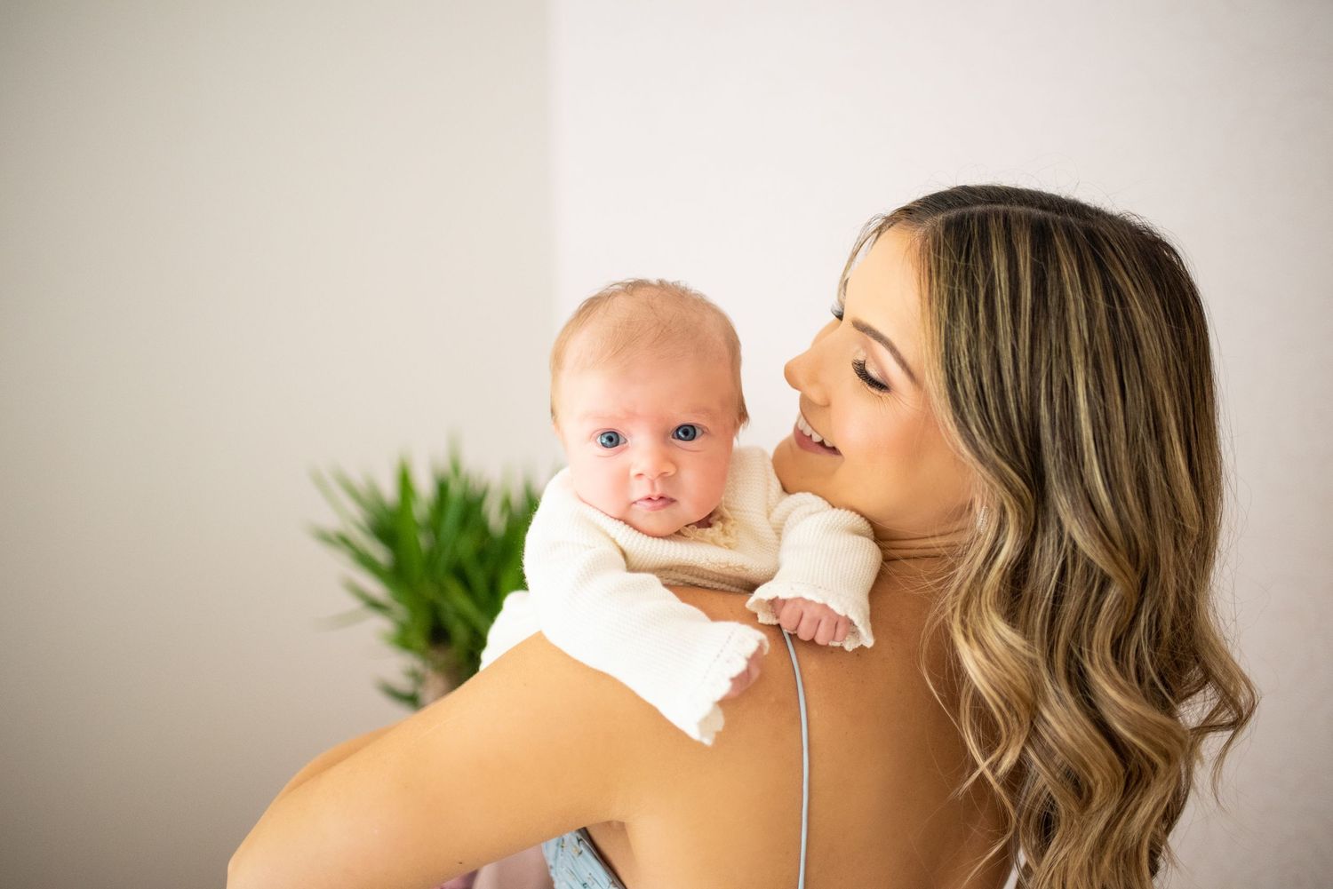 A parent and baby share joyful moments together in a series of candid lifestyle photos against a light background.