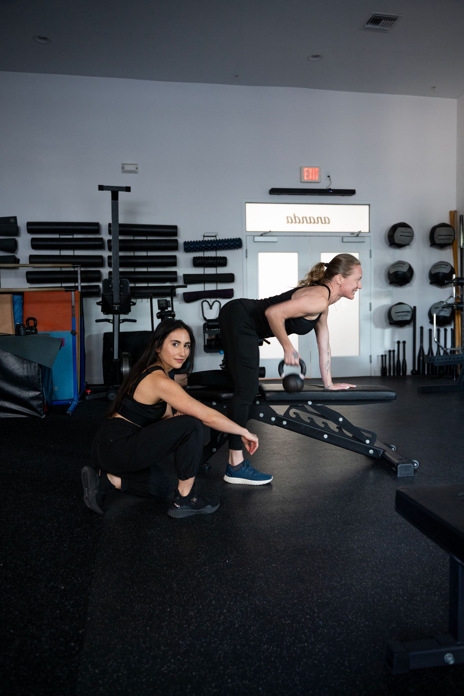 Person performing mountain climber exercise progression on dark gym floor with weight racks in background.