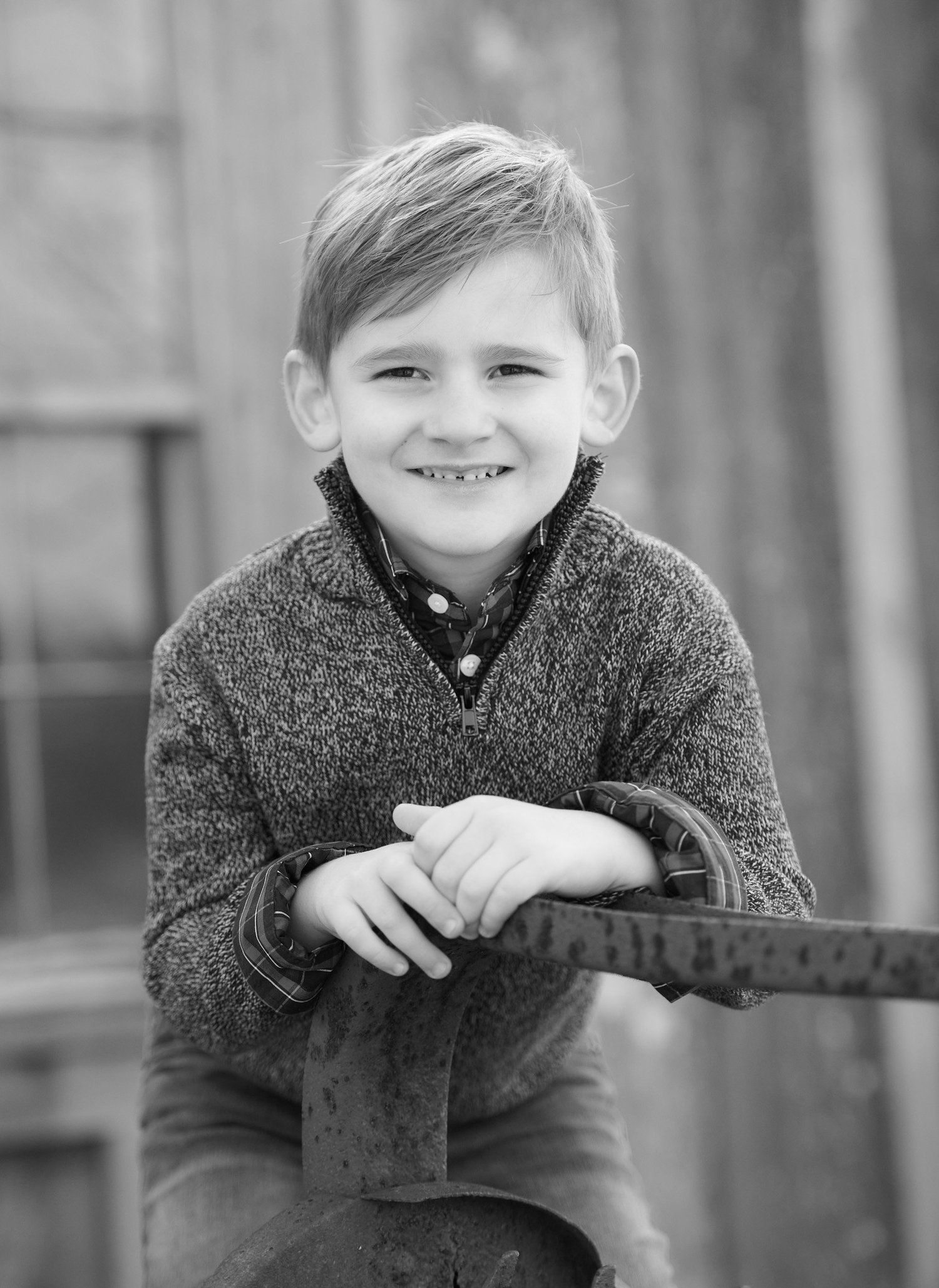 Black and white portrait series showing a child in a knit sweater expressing different emotions and poses.