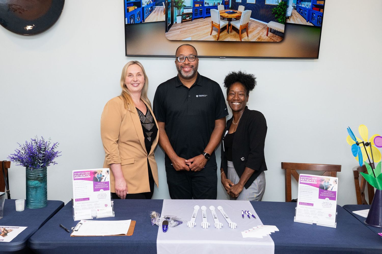 Business professionals gathered at a networking event with promotional materials and signage displayed.