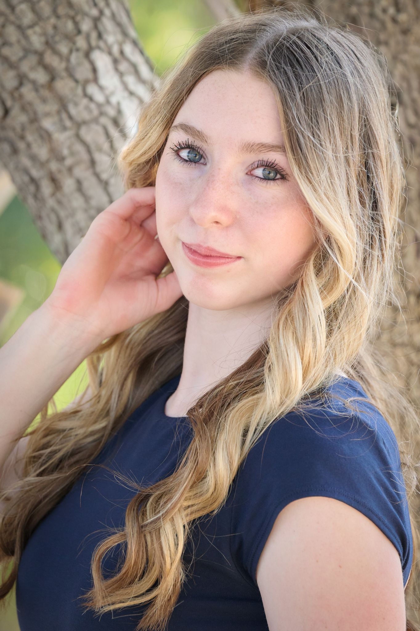 Close-up portrait series with natural lighting showing different angles against tree backdrop.