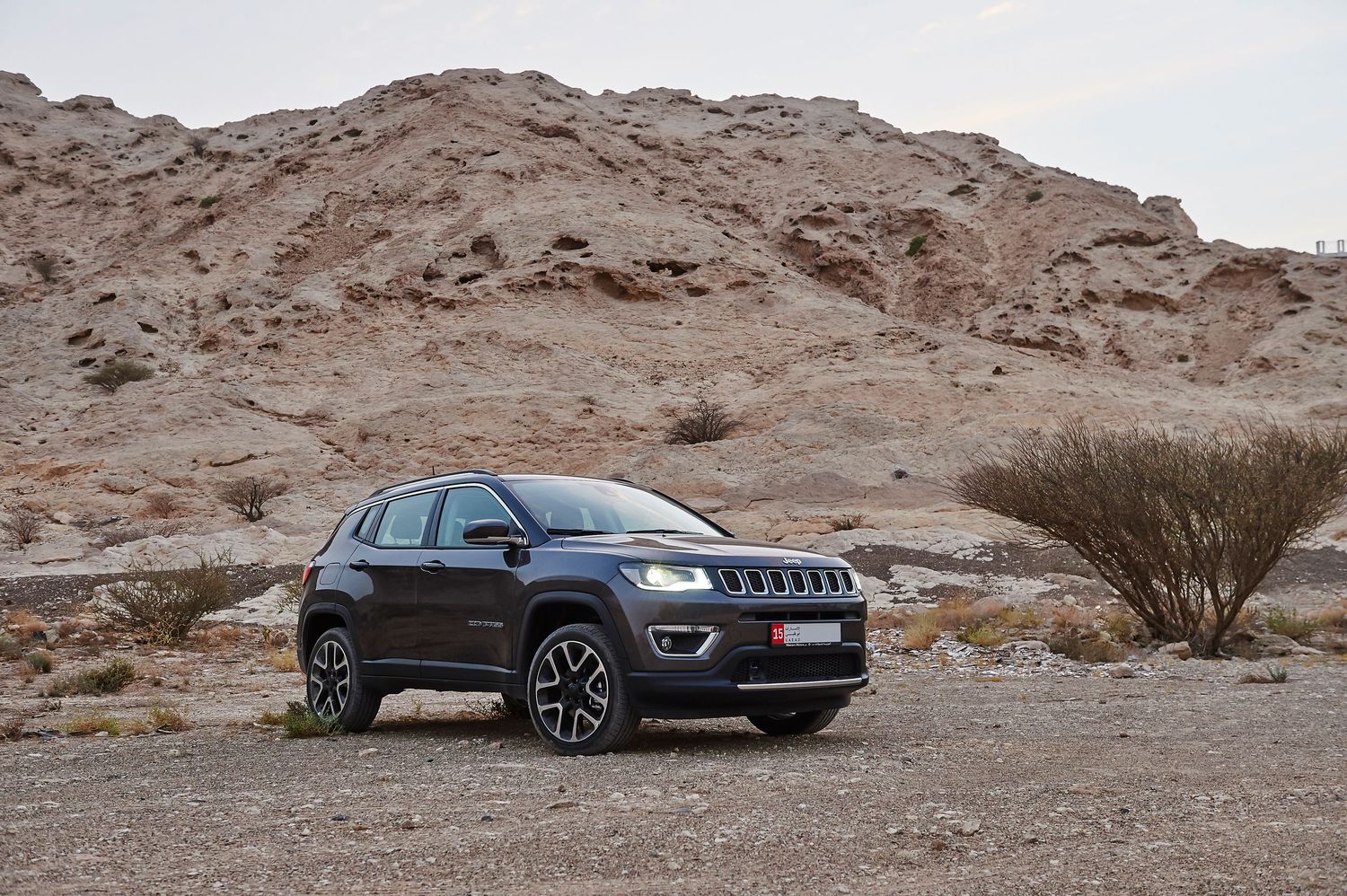 Black Jeep Compass SUV shown in profile views against desert mountain backdrop.