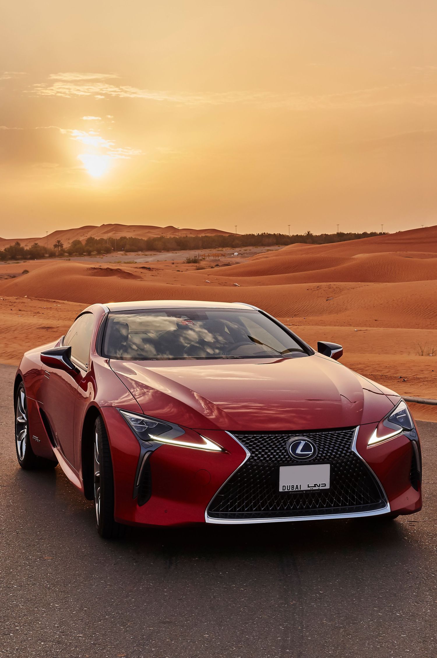 Dramatic angles of red Lexus concept car showcased in desert environment at golden hour.