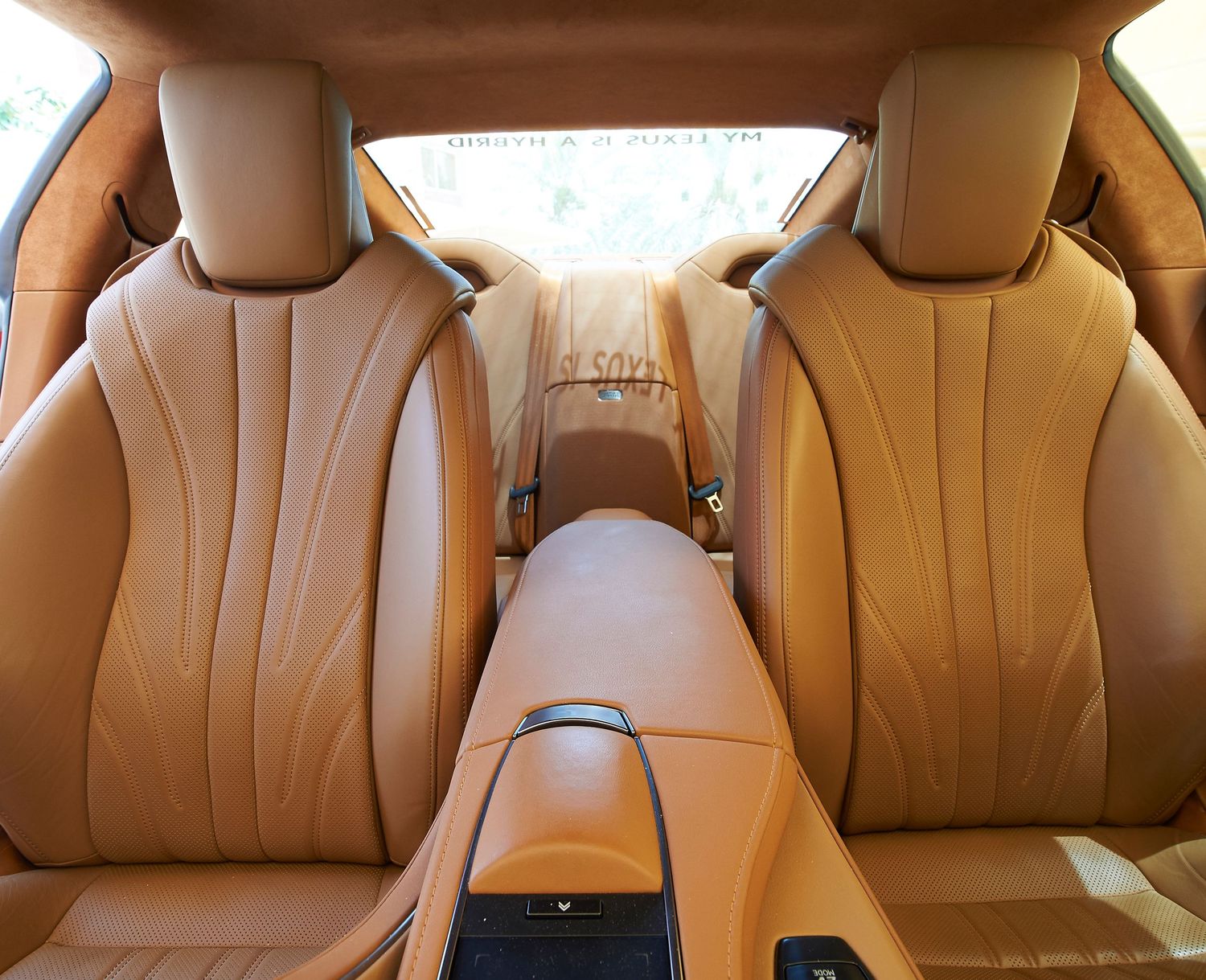 Luxurious tan leather rear seats in a Lexus vehicle with center armrest.