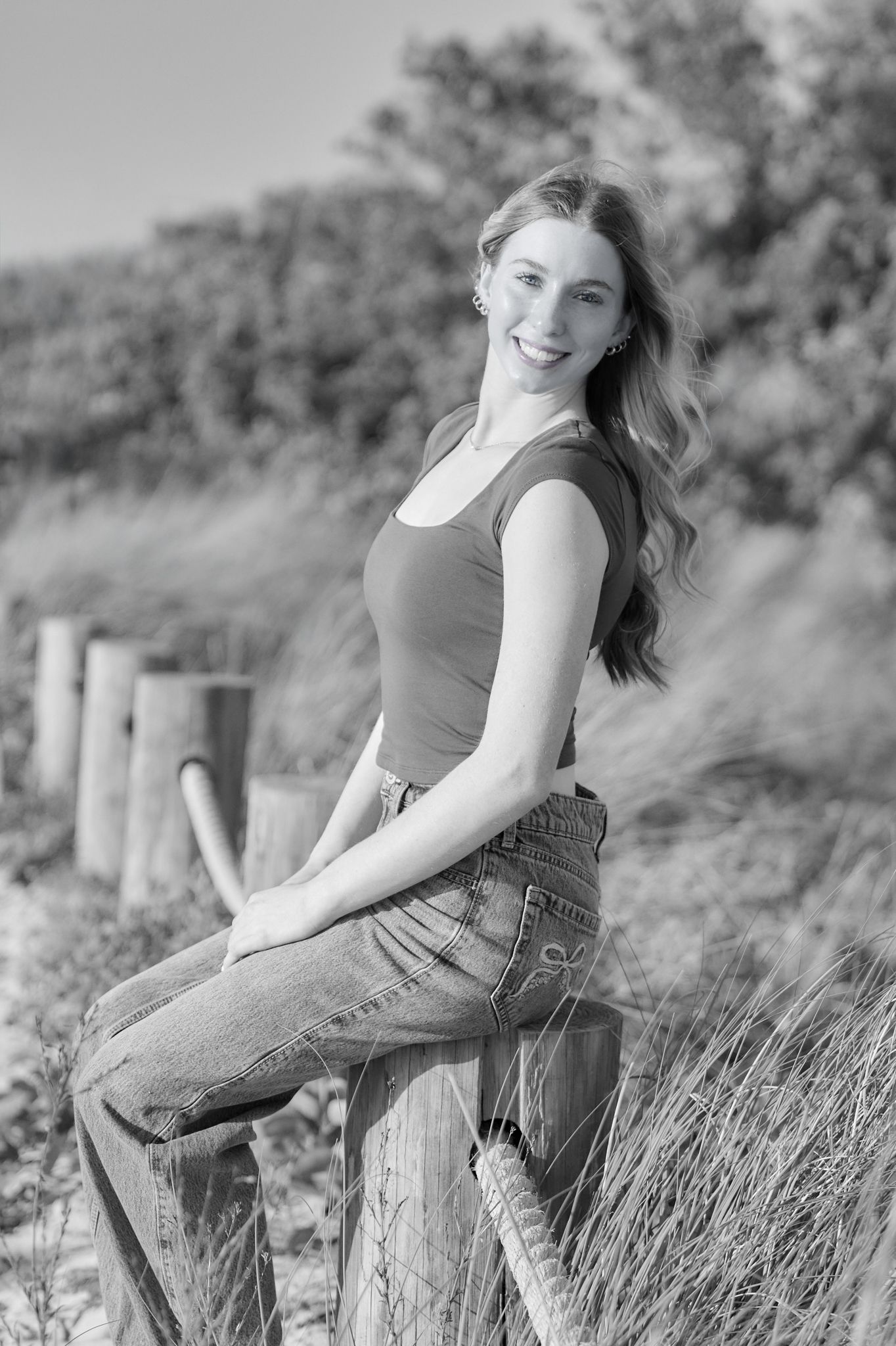 Black and white outdoor portraits showing casual poses on wooden fence with rural landscape behind.