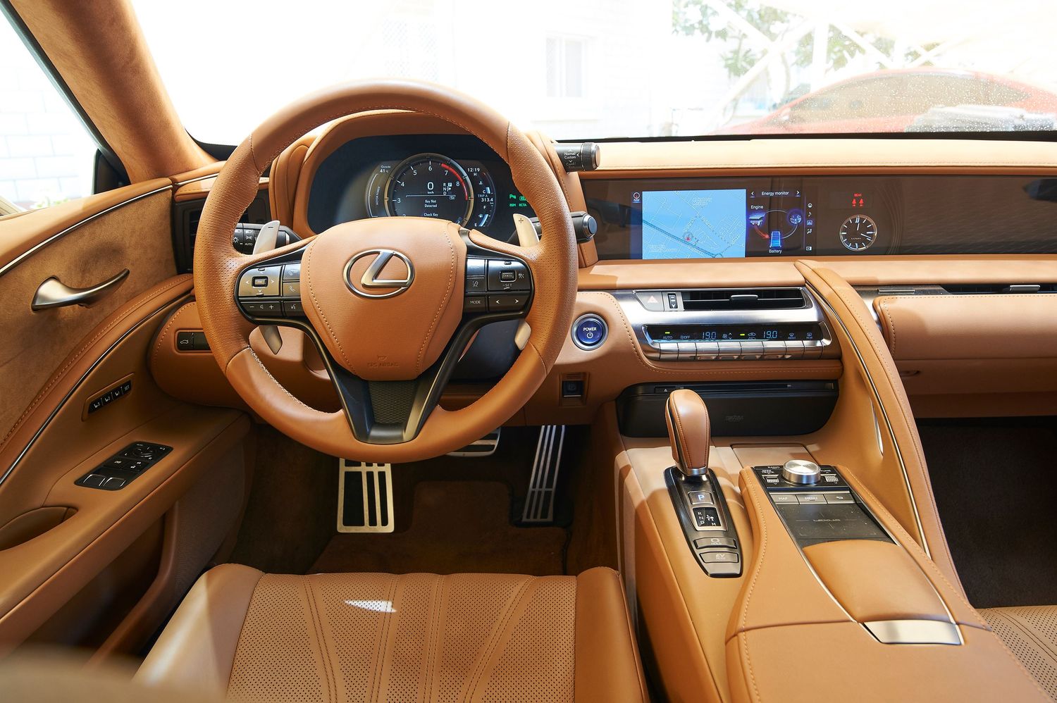 Interior view of a Lexus luxury car dashboard showing tan leather and modern digital displays.
