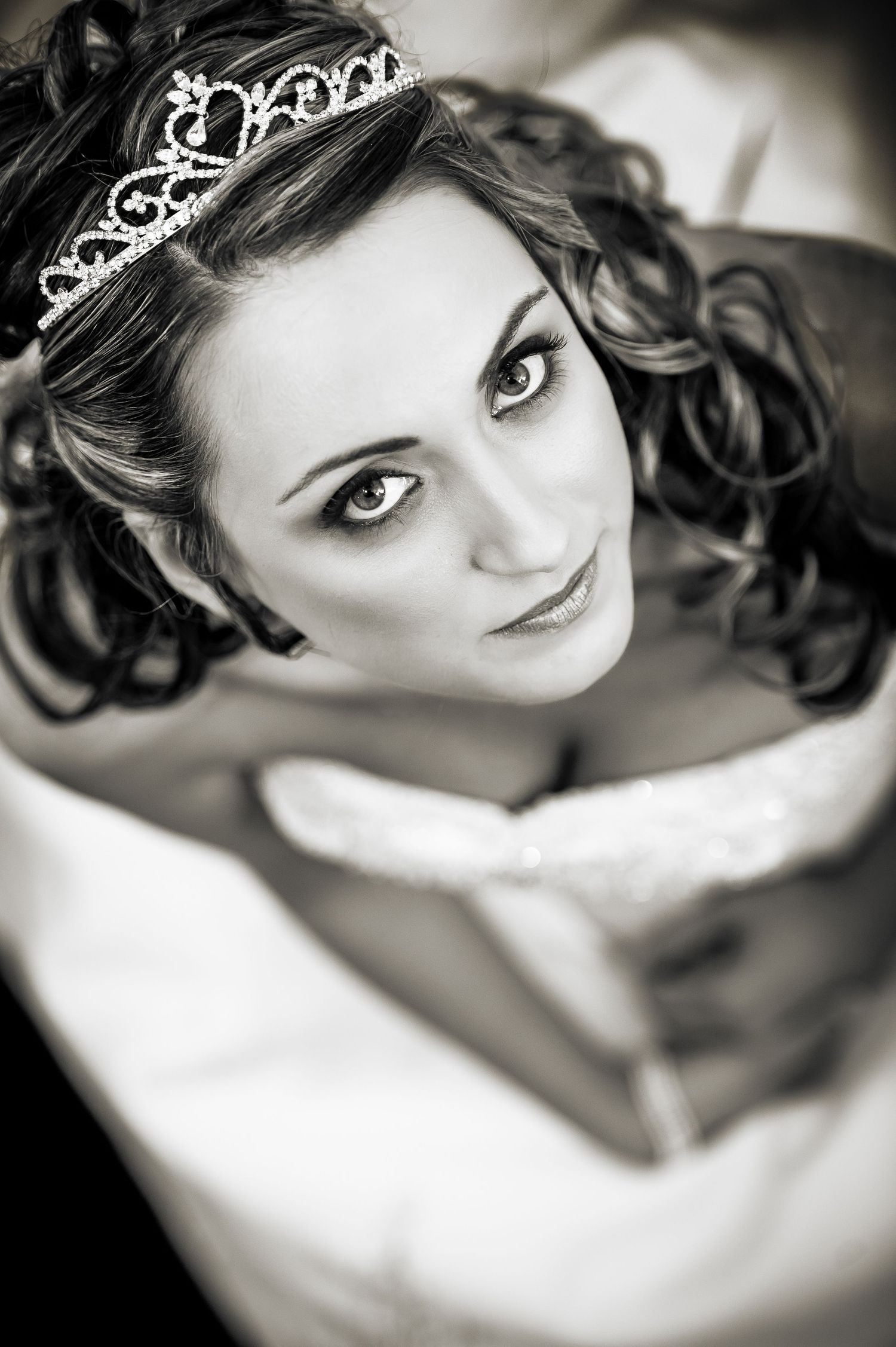Black and white portrait of someone wearing a delicate tiara and elegant curls in a romantic style.