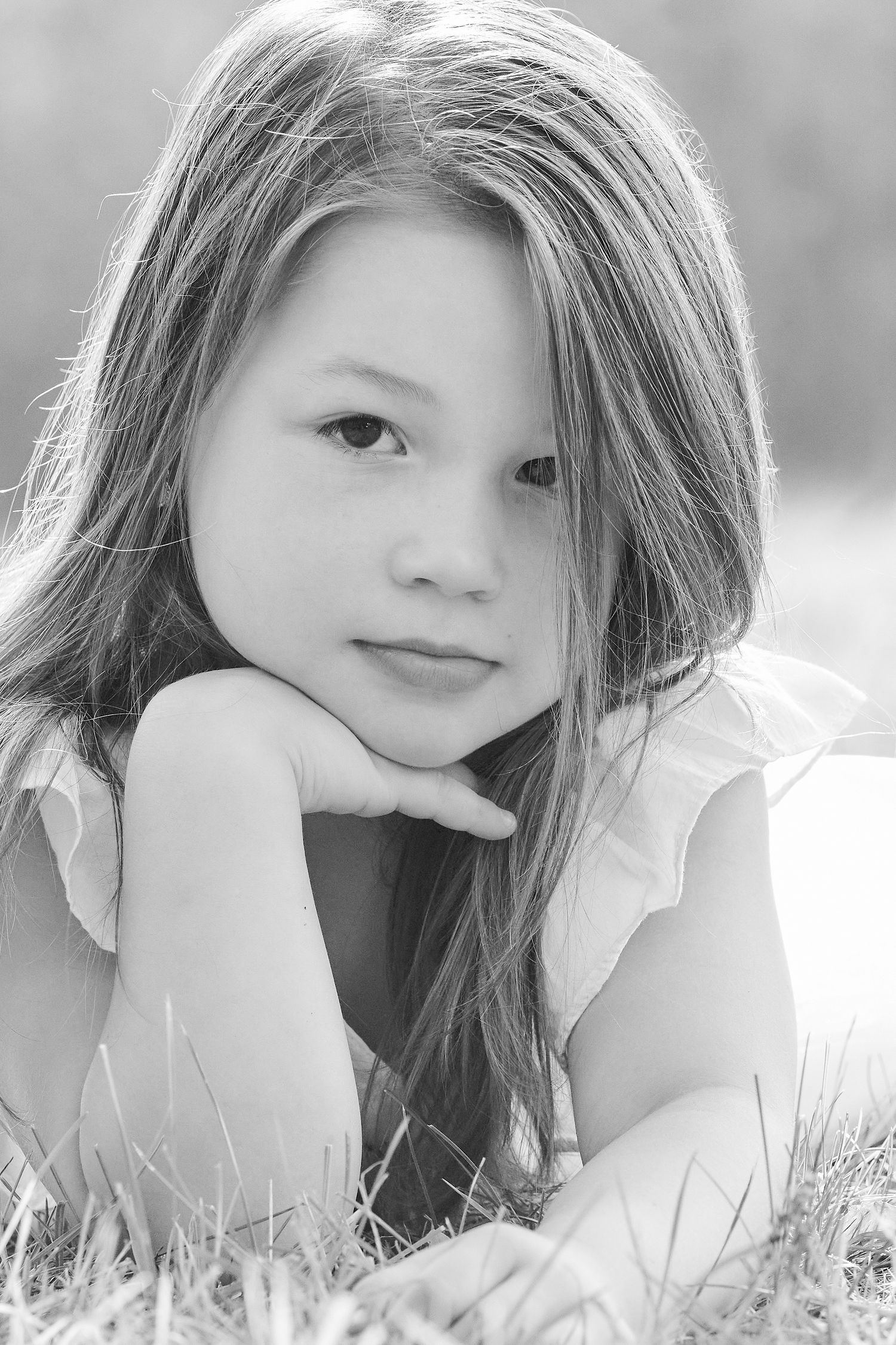 Black and white portrait series showing artistic poses on grass.