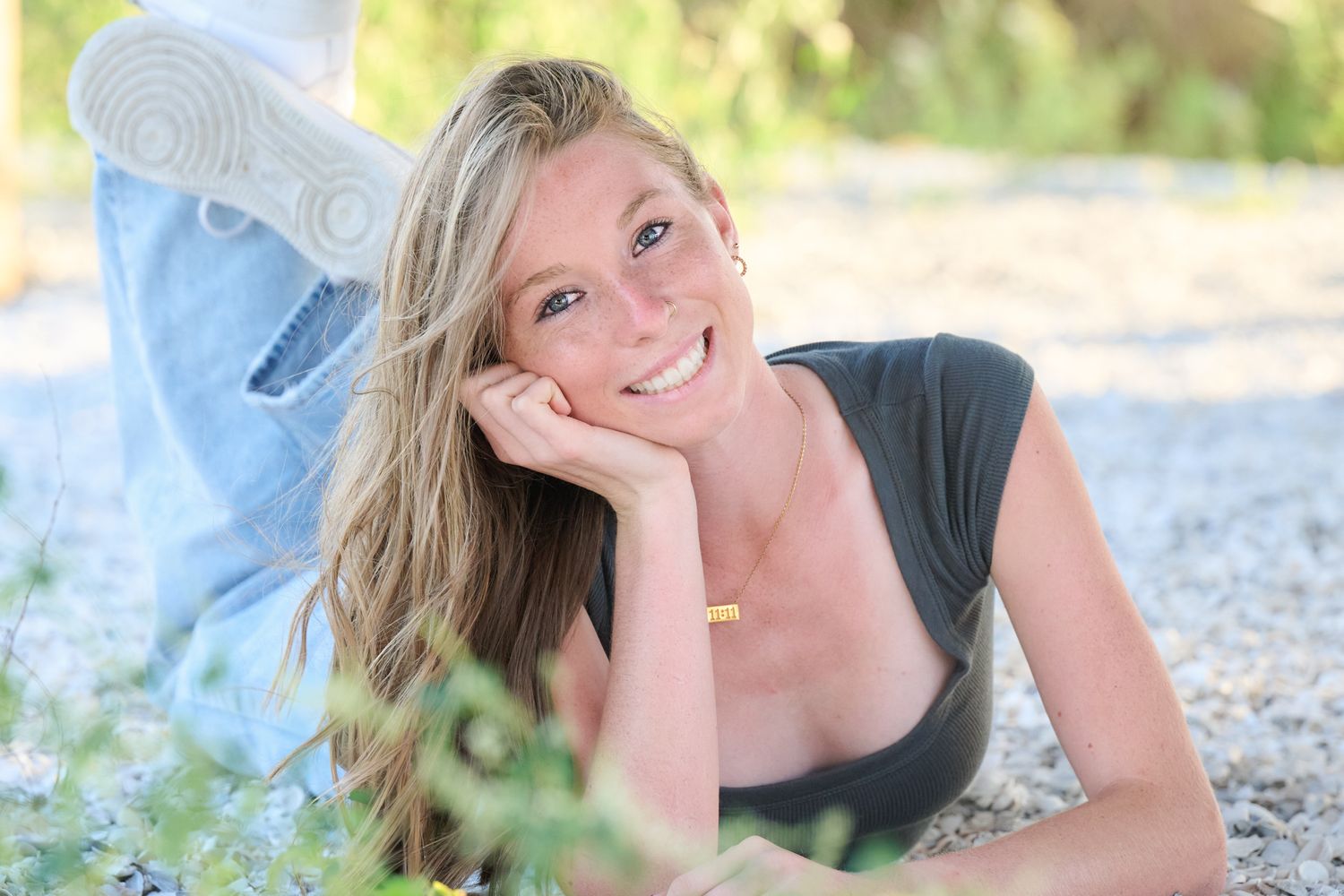 A series of outdoor portrait photos showing someone laying on a rocky beach in casual attire.