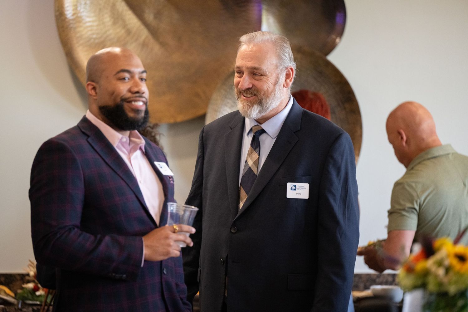 Two people engaged in friendly conversation at a professional networking event.