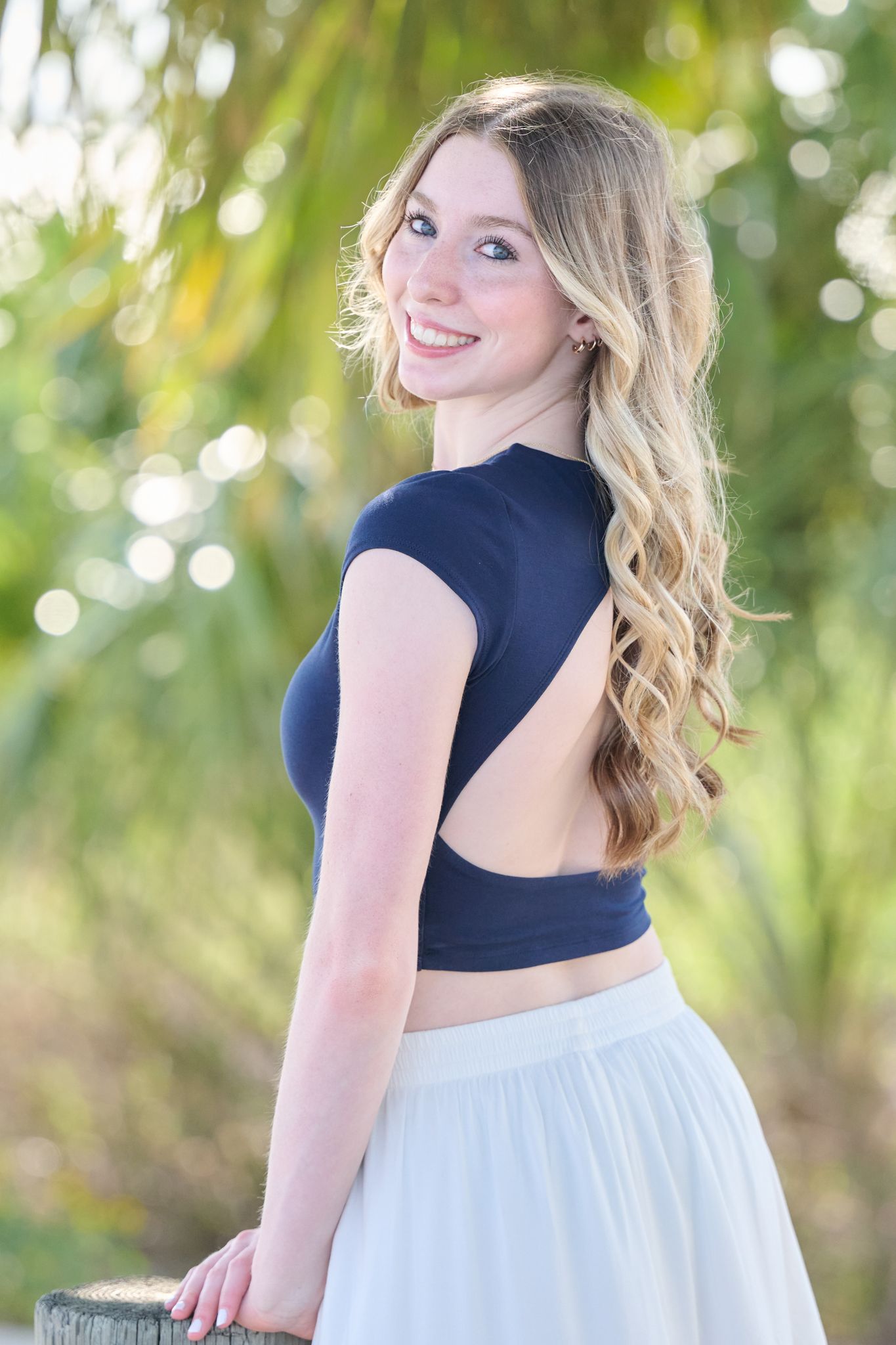 A collection of photos featuring someone in a navy top and white skirt posing outdoors with natural lighting.