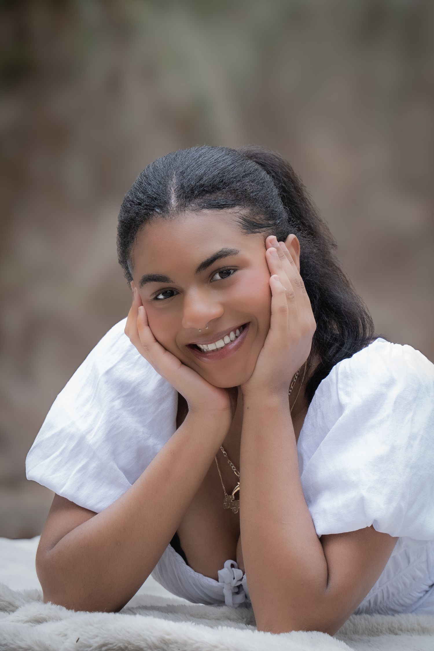 A series of candid portraits showing someone laying down in a white outfit against a soft blurred background.