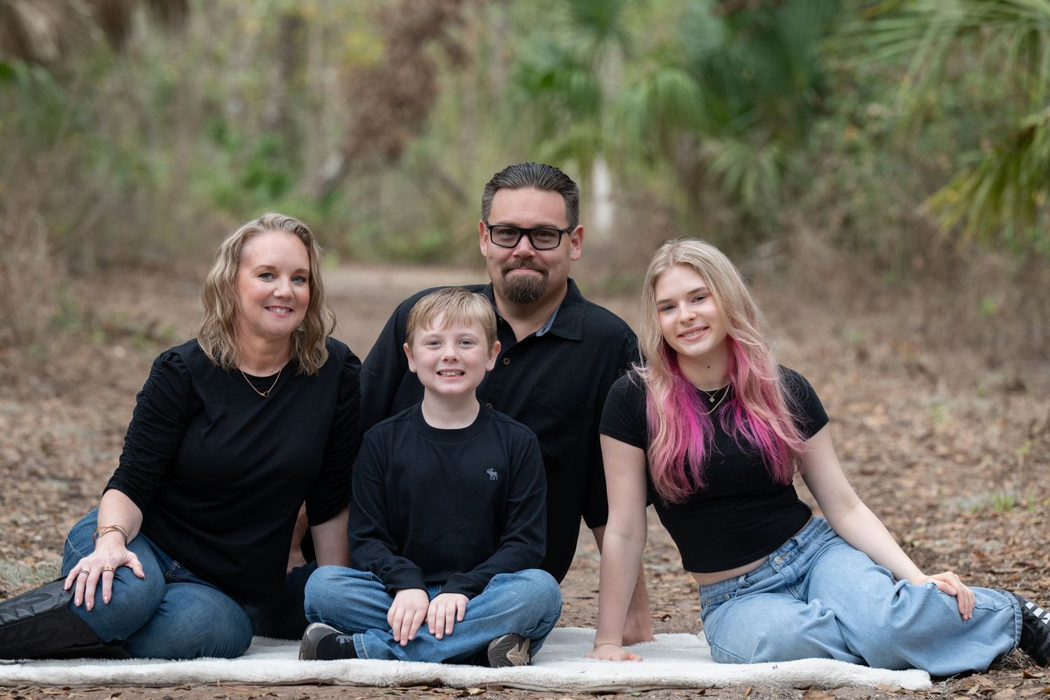 A series of candid outdoor family photos showing people sitting and laughing together on the ground in a natural setting.