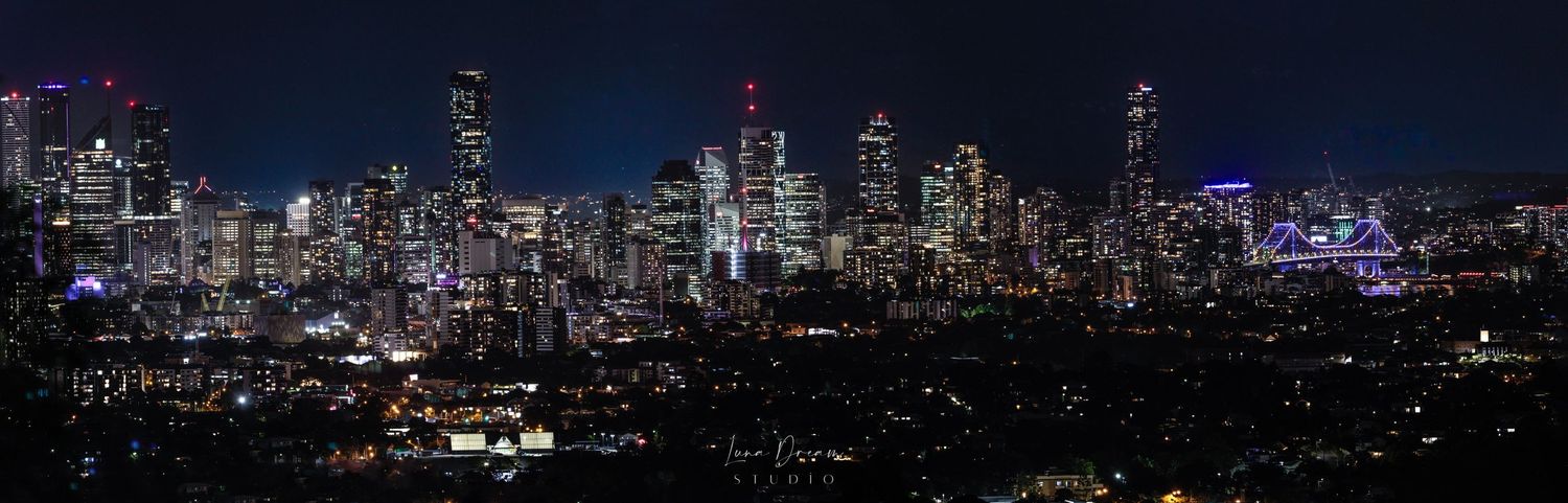 Brisbane city skyline glowing at night, featuring sparkling skyscrapers, urban photography, and panoramic metropolitan lights