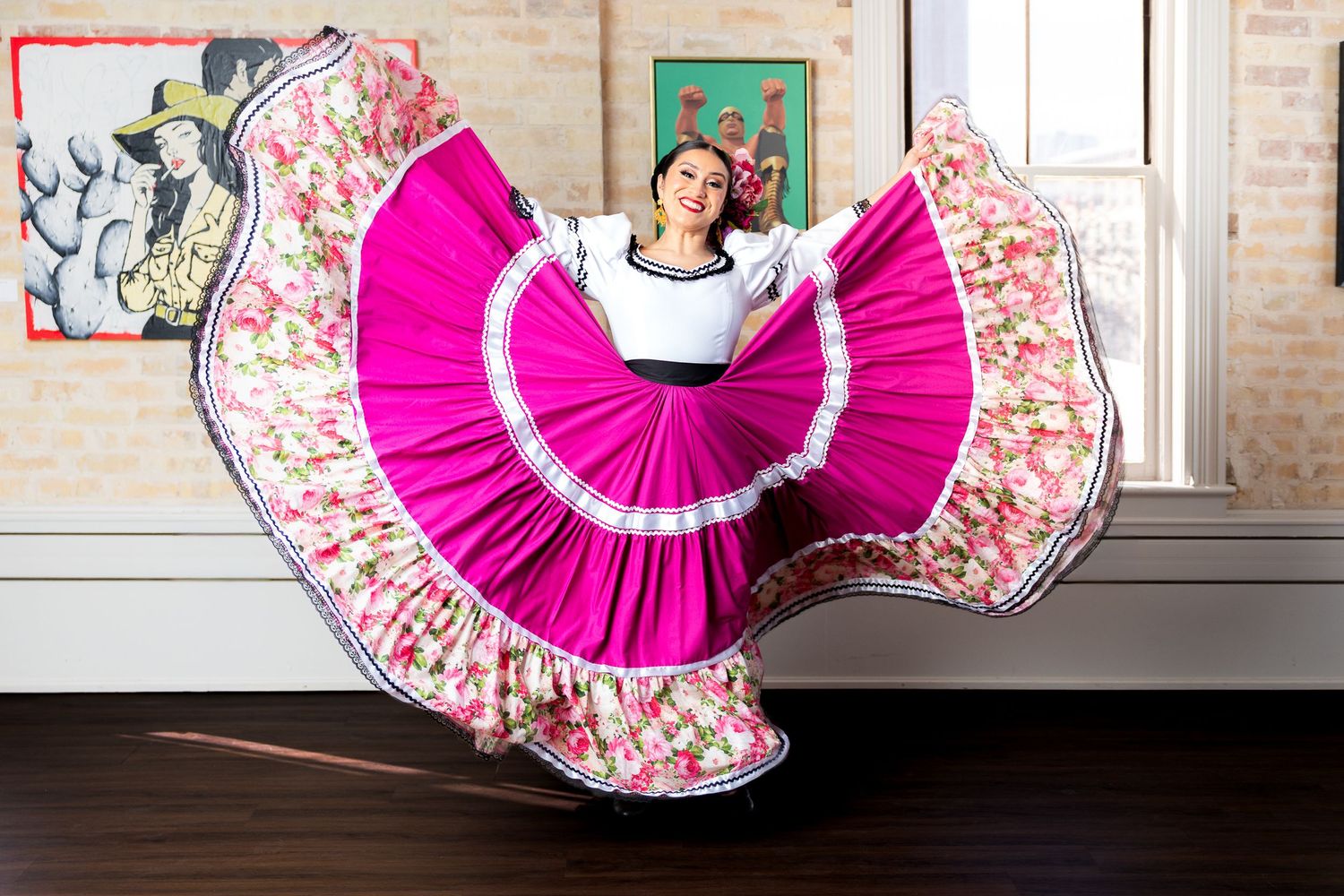 Dancer in a vibrant pink traditional Mexican folklorico dress spins gracefully, creating a circular motion effect.