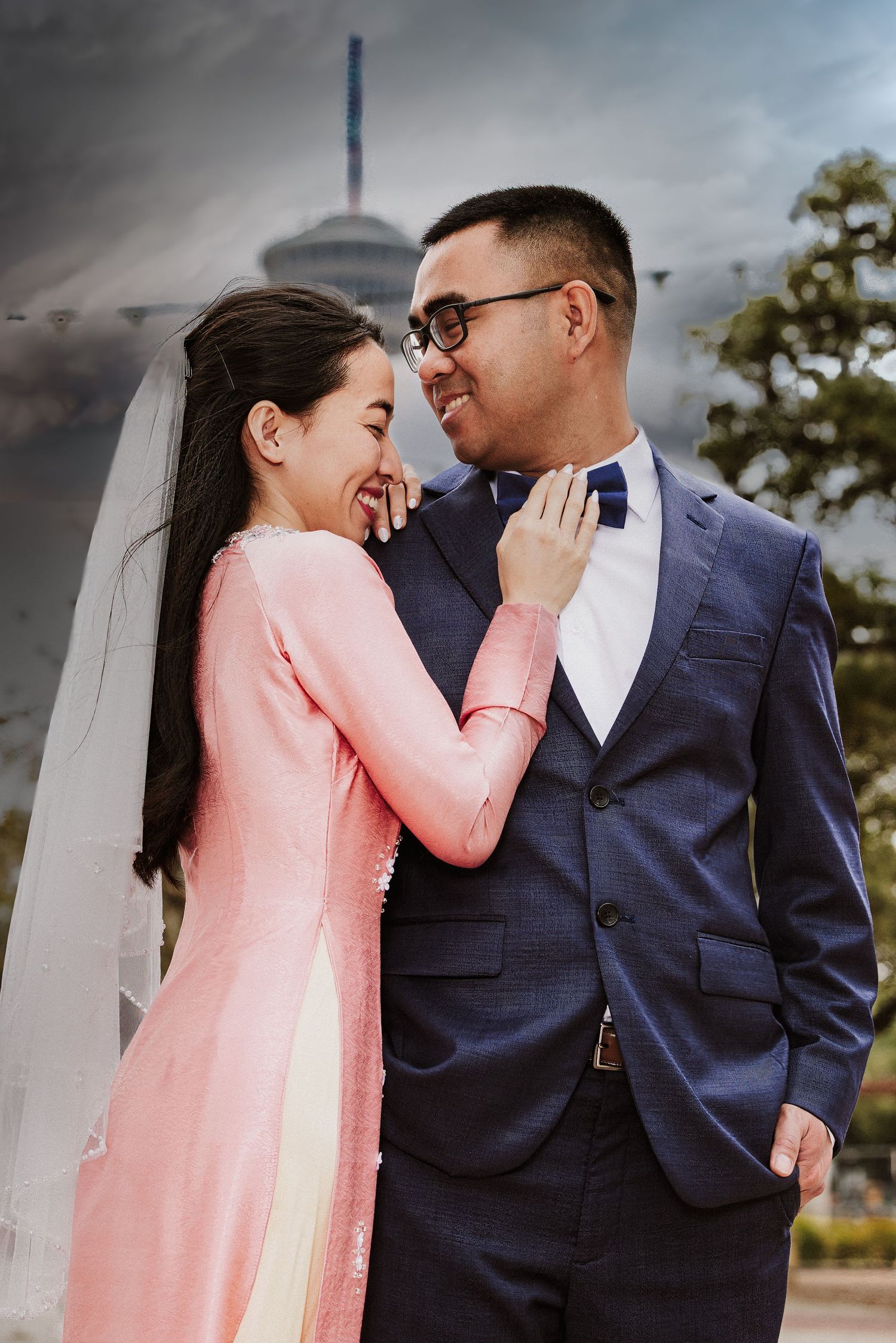 A couple in contrasting pink and navy outfits share an intimate moment during an outdoor photo session.