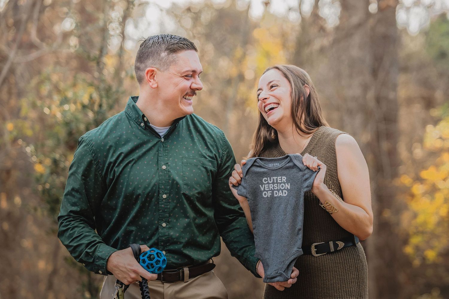 A couple shares a joyful moment together outdoors during an autumn photo session.