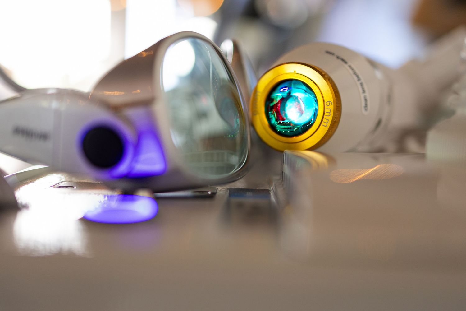 Close-up of colorful camera lenses and photography equipment displayed on a white surface.