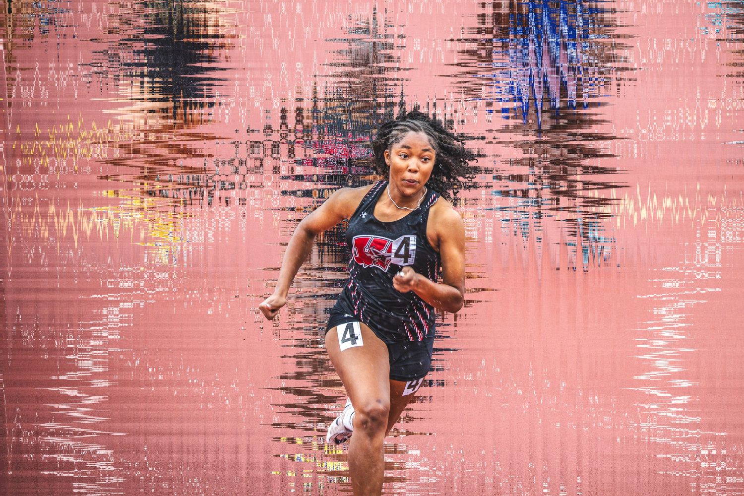 Female USA track athlete sprinting in competition wearing navy uniform, captured mid-stride against a colorful abstract background.