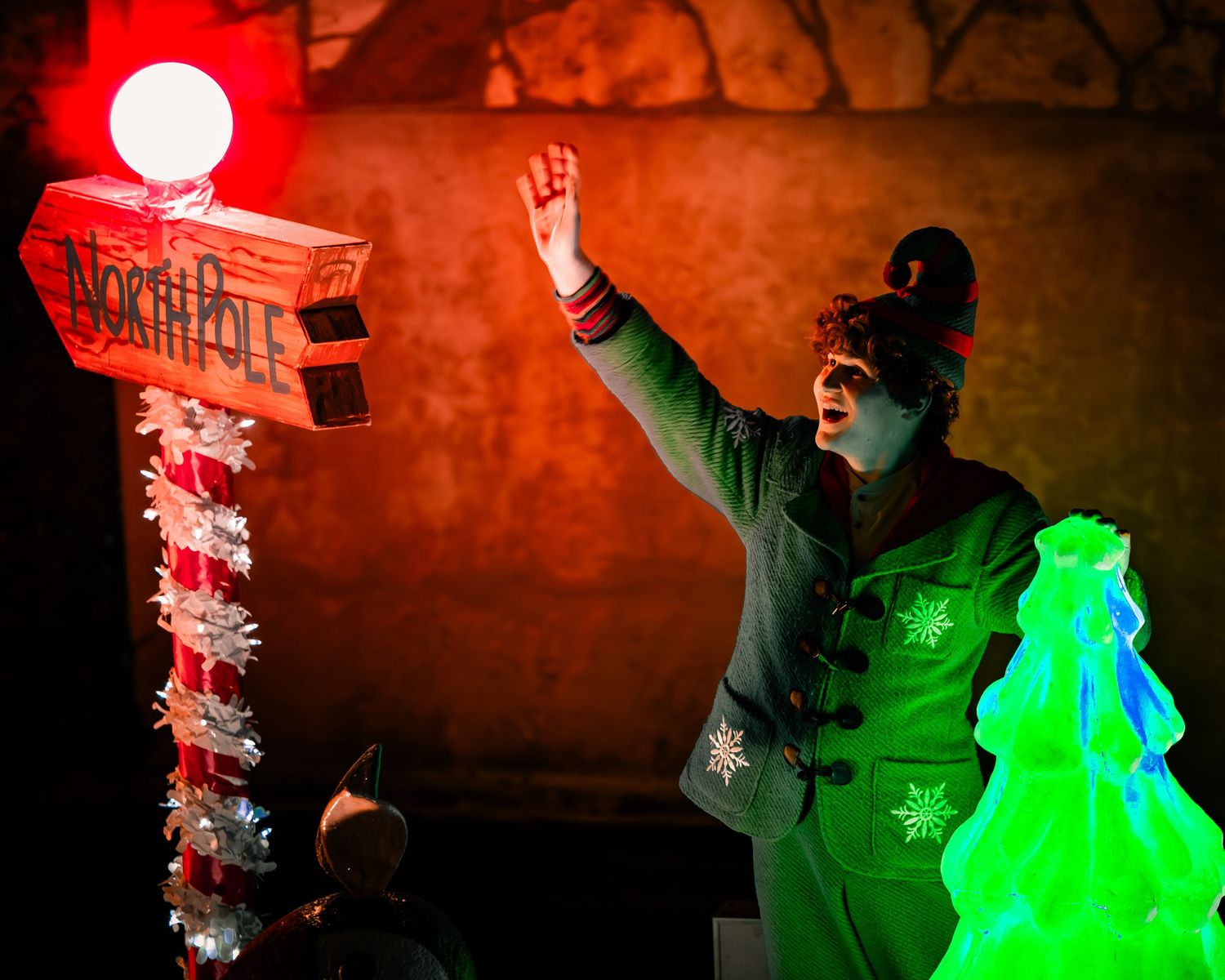 Person illuminated by red and green lights creates an artistic light painting in the darkness.