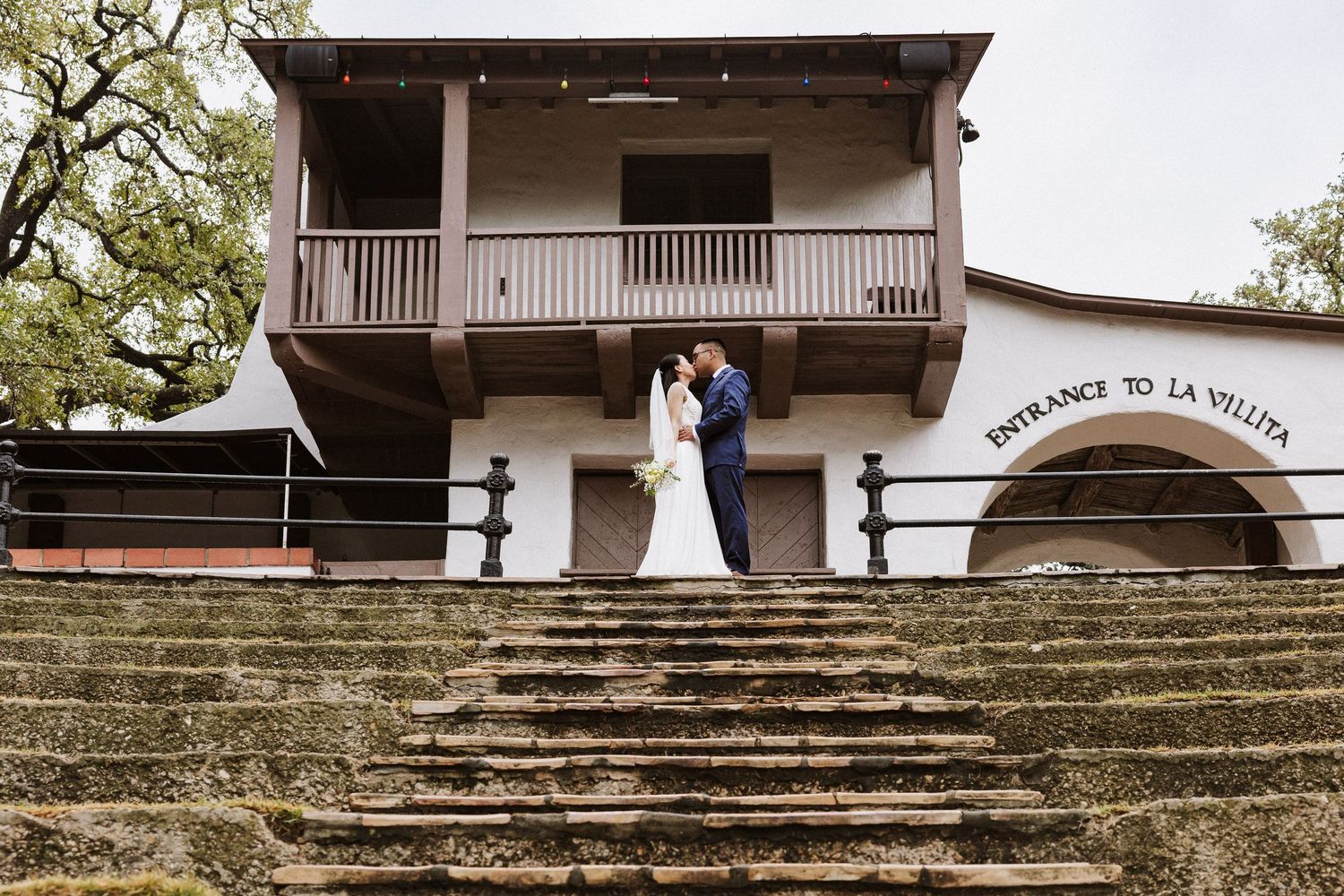 Stone steps and architecture create a romantic backdrop at a historic mission or church venue.