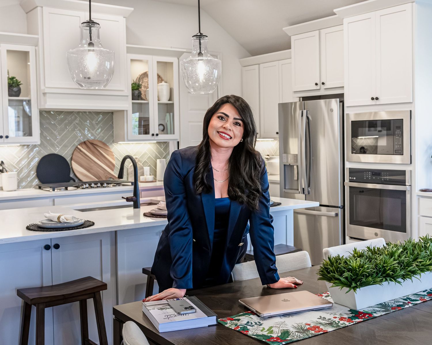 A bright modern kitchen with white cabinets, pendant lighting, and a view through multiple angles showing the layout.