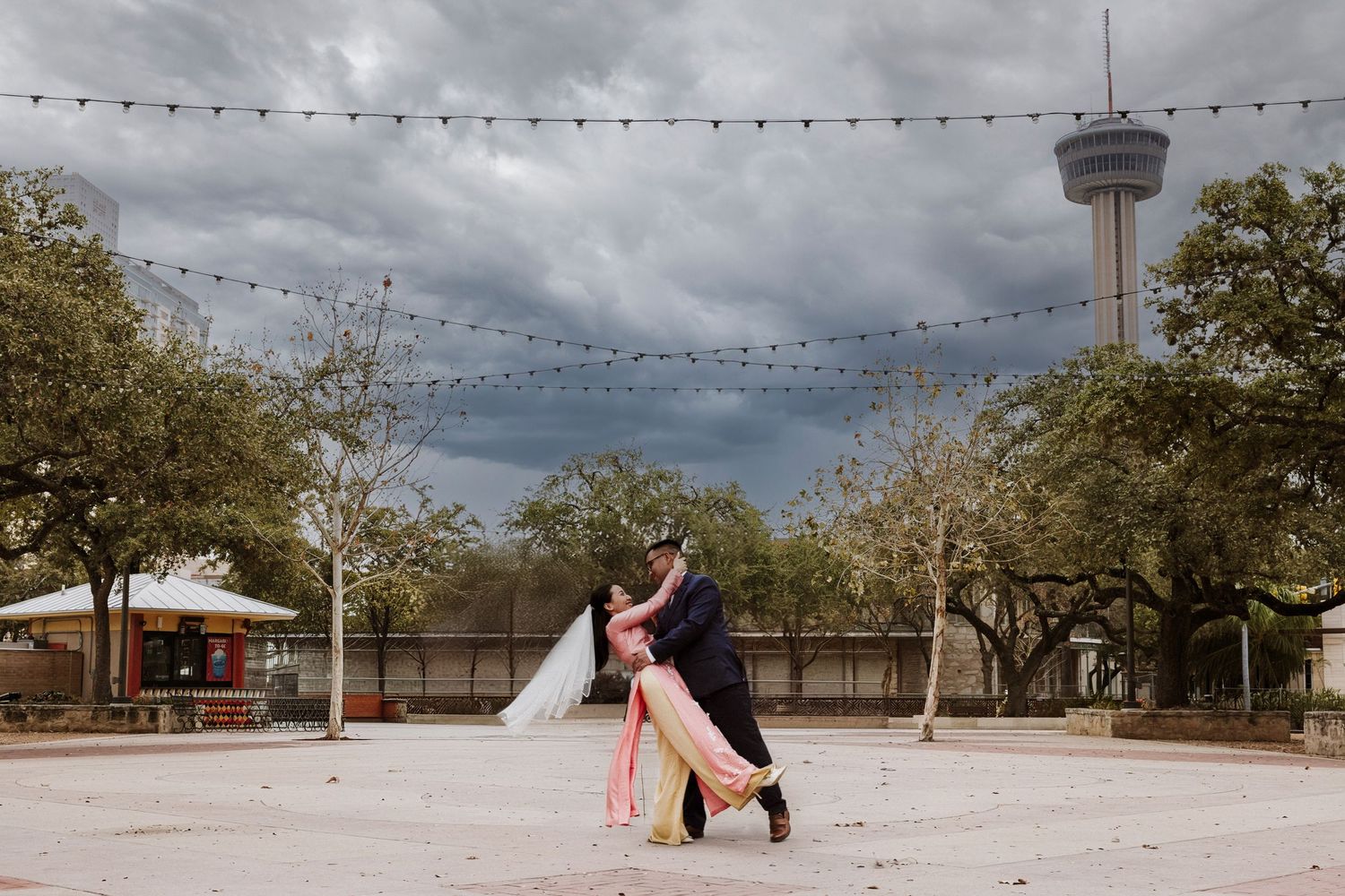 A romantic wedding photo collage showing multiple outdoor scenes with string lights and the Tower of Americas in San Antonio.