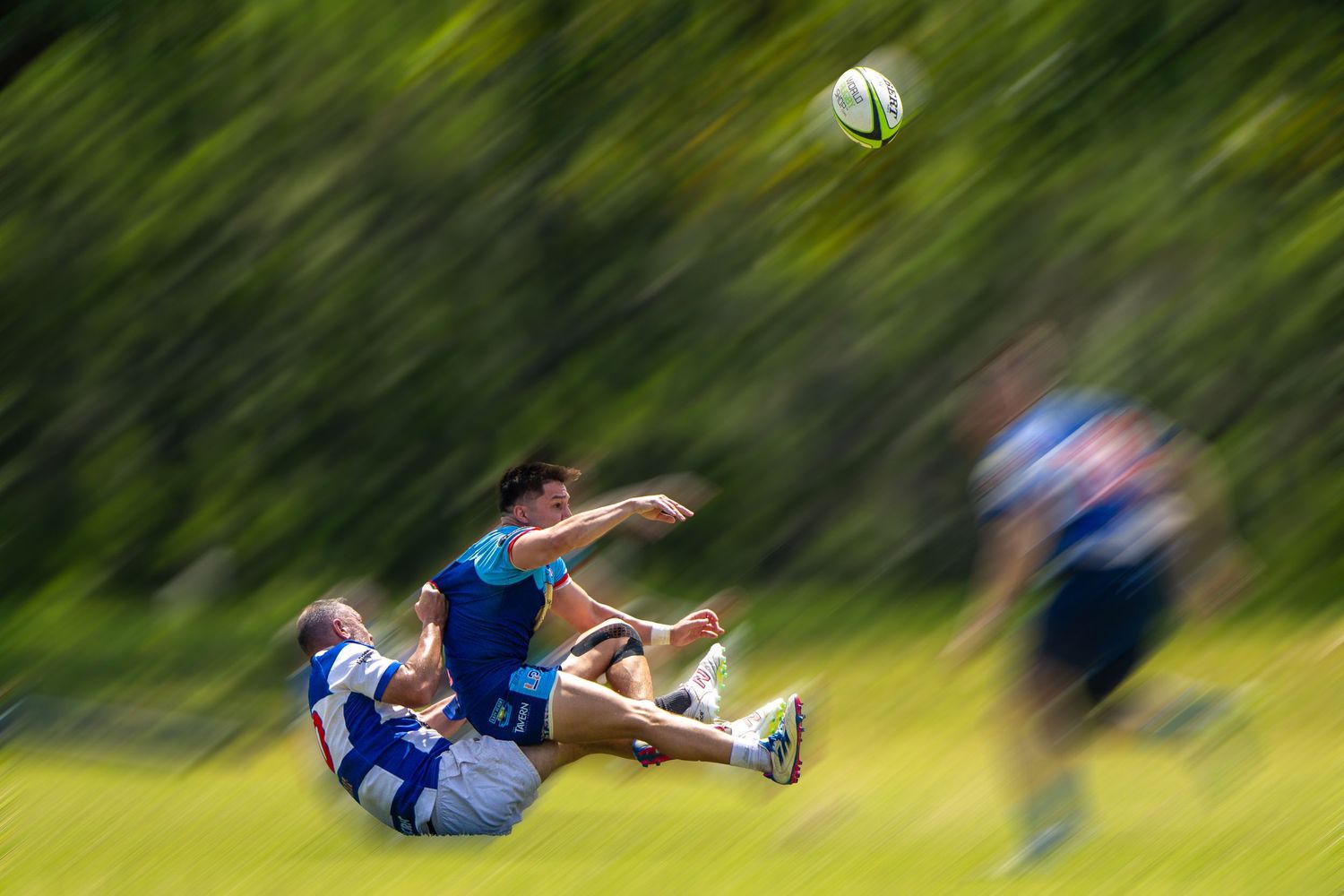 Dynamic action shot of soccer players colliding mid-air during an outdoor match.