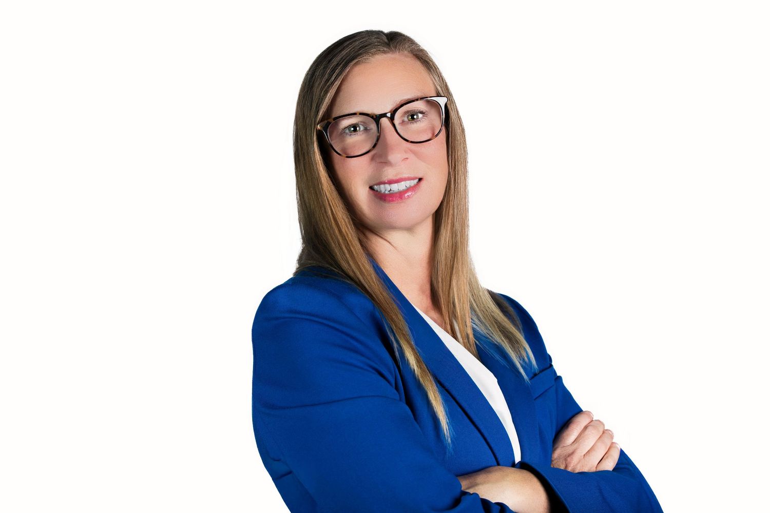 Professional wearing glasses and a royal blue blazer smiles warmly in a corporate headshot photo.