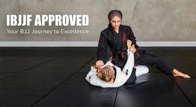 A female BJJ practitioner in a black gi performs a ground technique on a partner during an IBJJF approved training session.