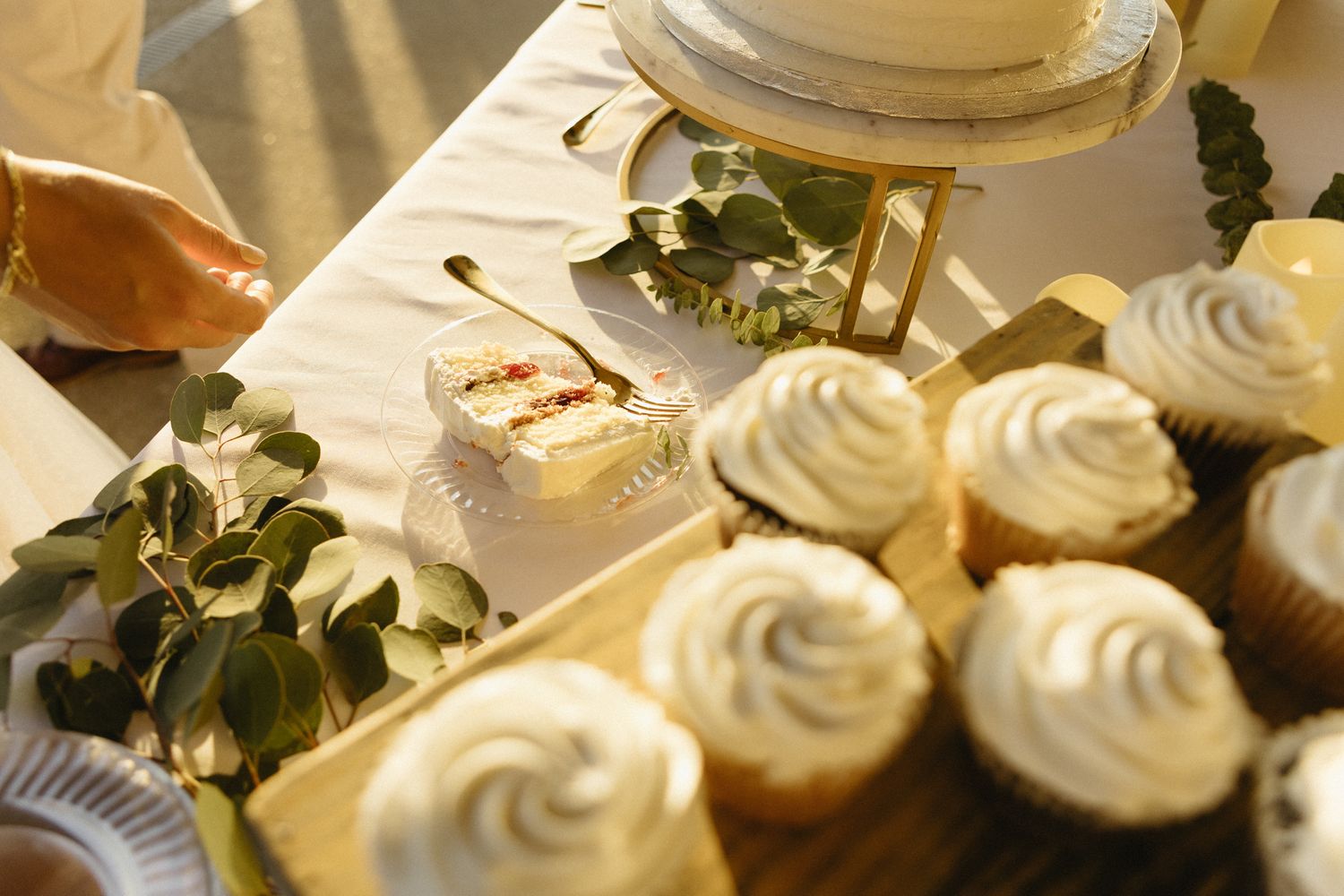 Close-up of elegantly decorated white frosted cupcakes arranged in a display.