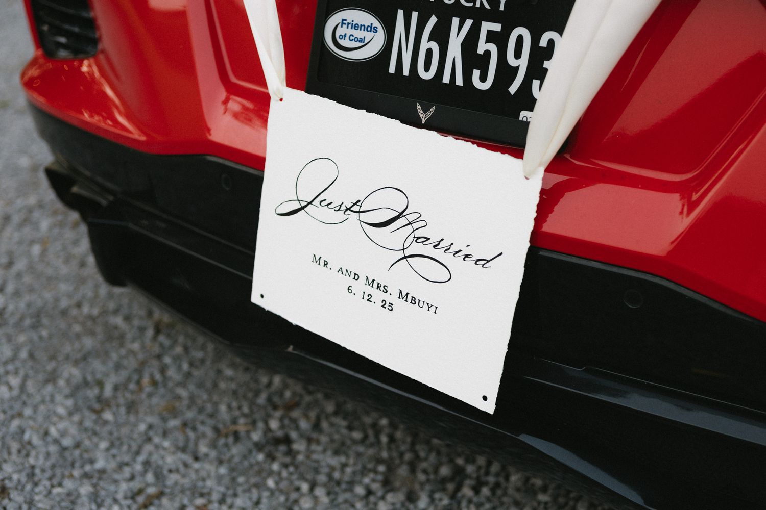 A red car with a license plate visible showing decorative signage.