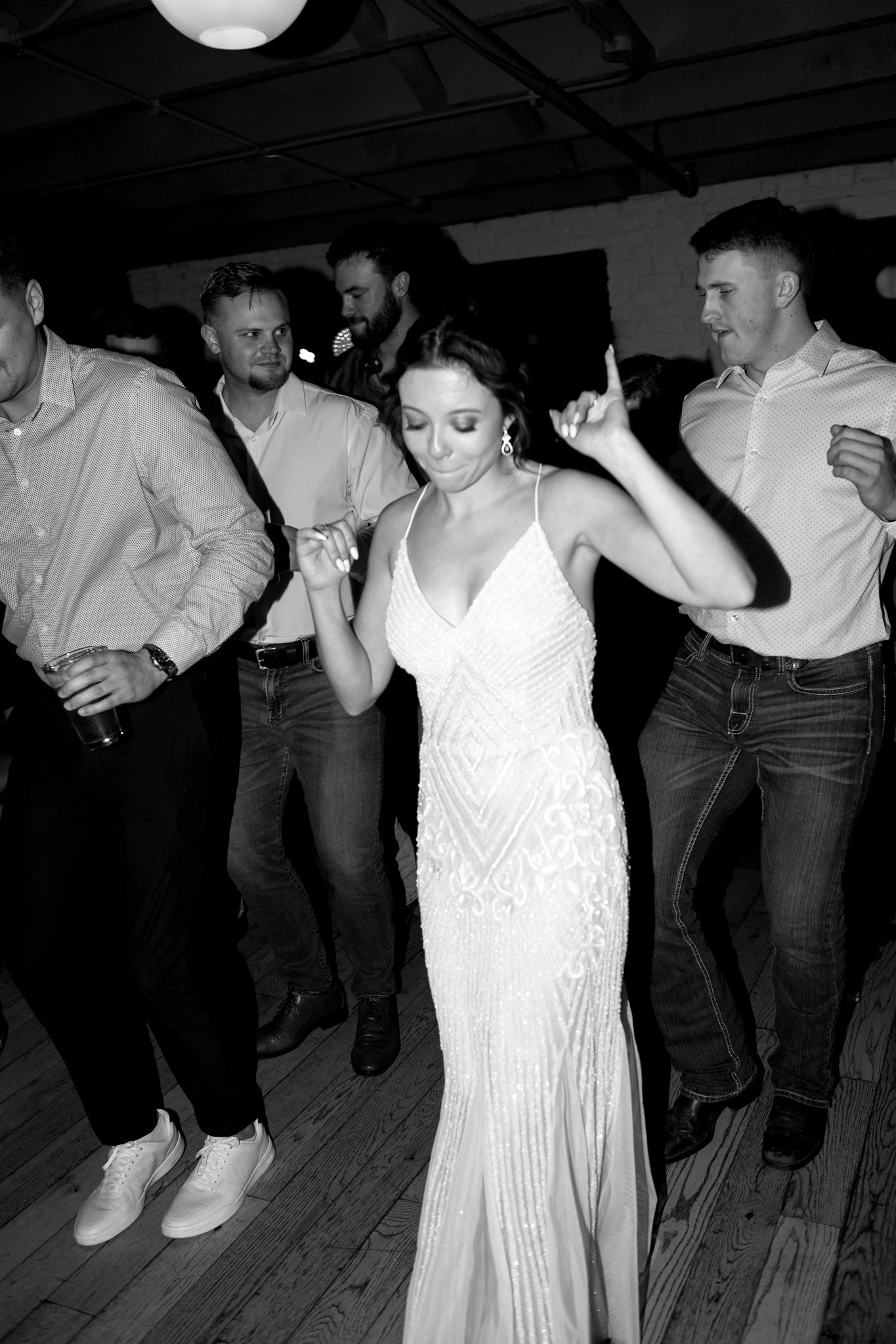 Formal event dancers enjoying themselves on a wooden dance floor in black and white.