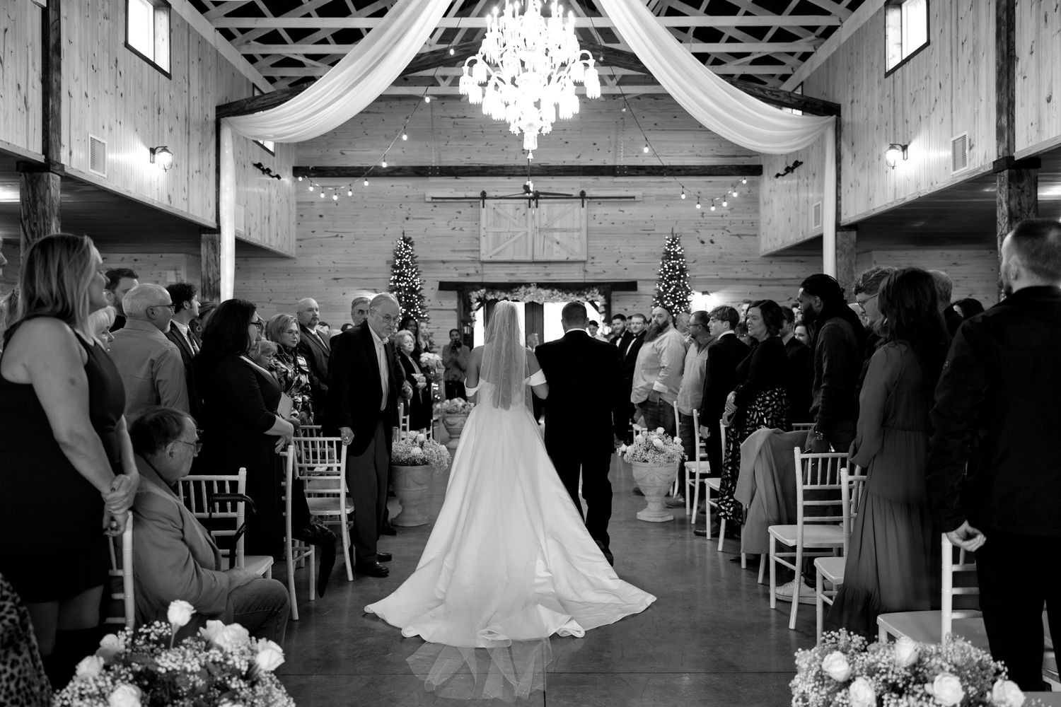Black and white wedding ceremony photos showing a grand ballroom with chandelier and guests seated in rows.