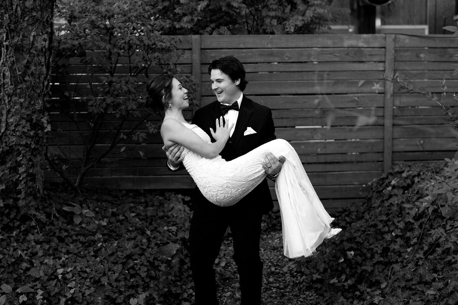 Classic black and white wedding portrait in a garden setting.