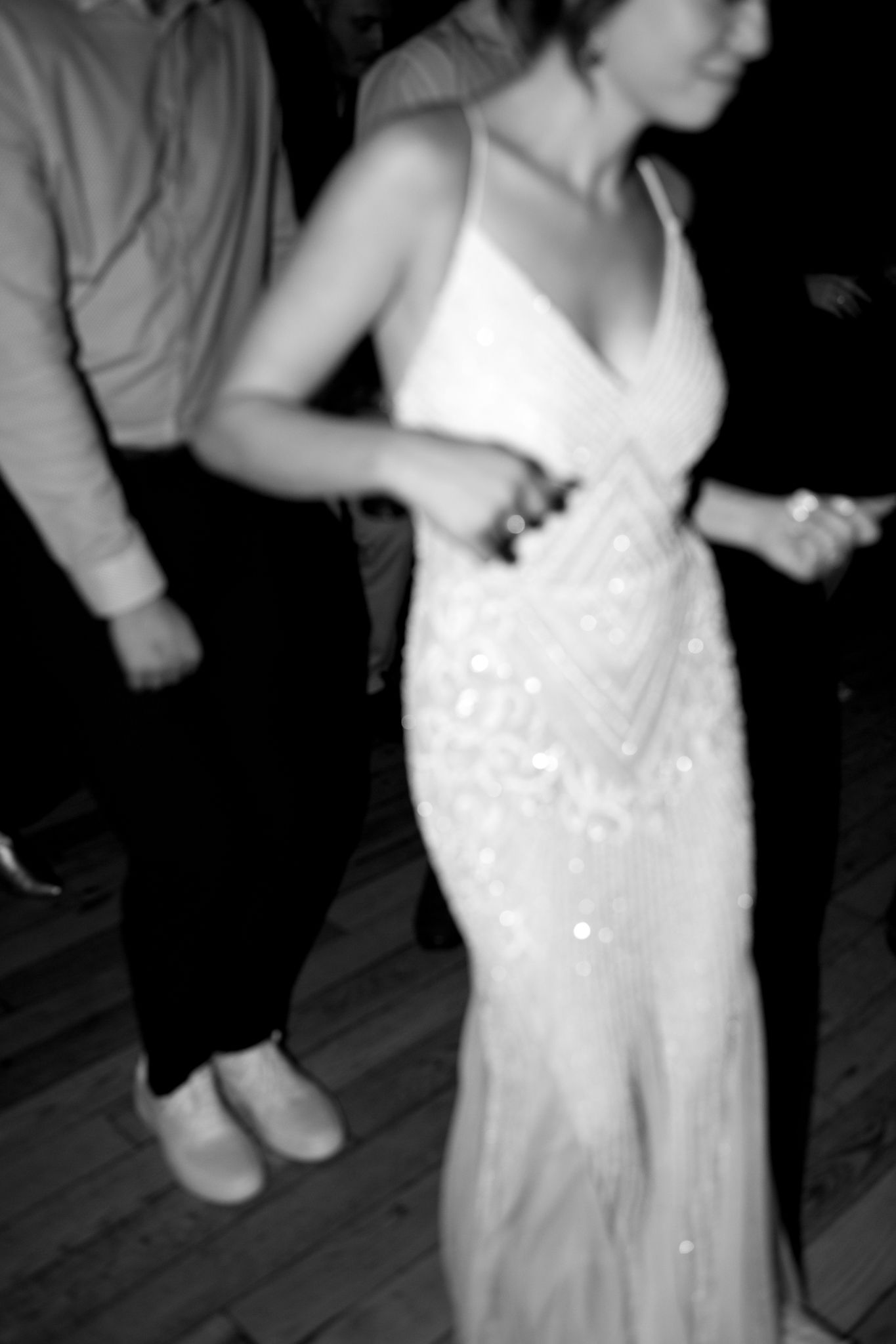 A person in a sparkly white wedding gown dances during a reception.