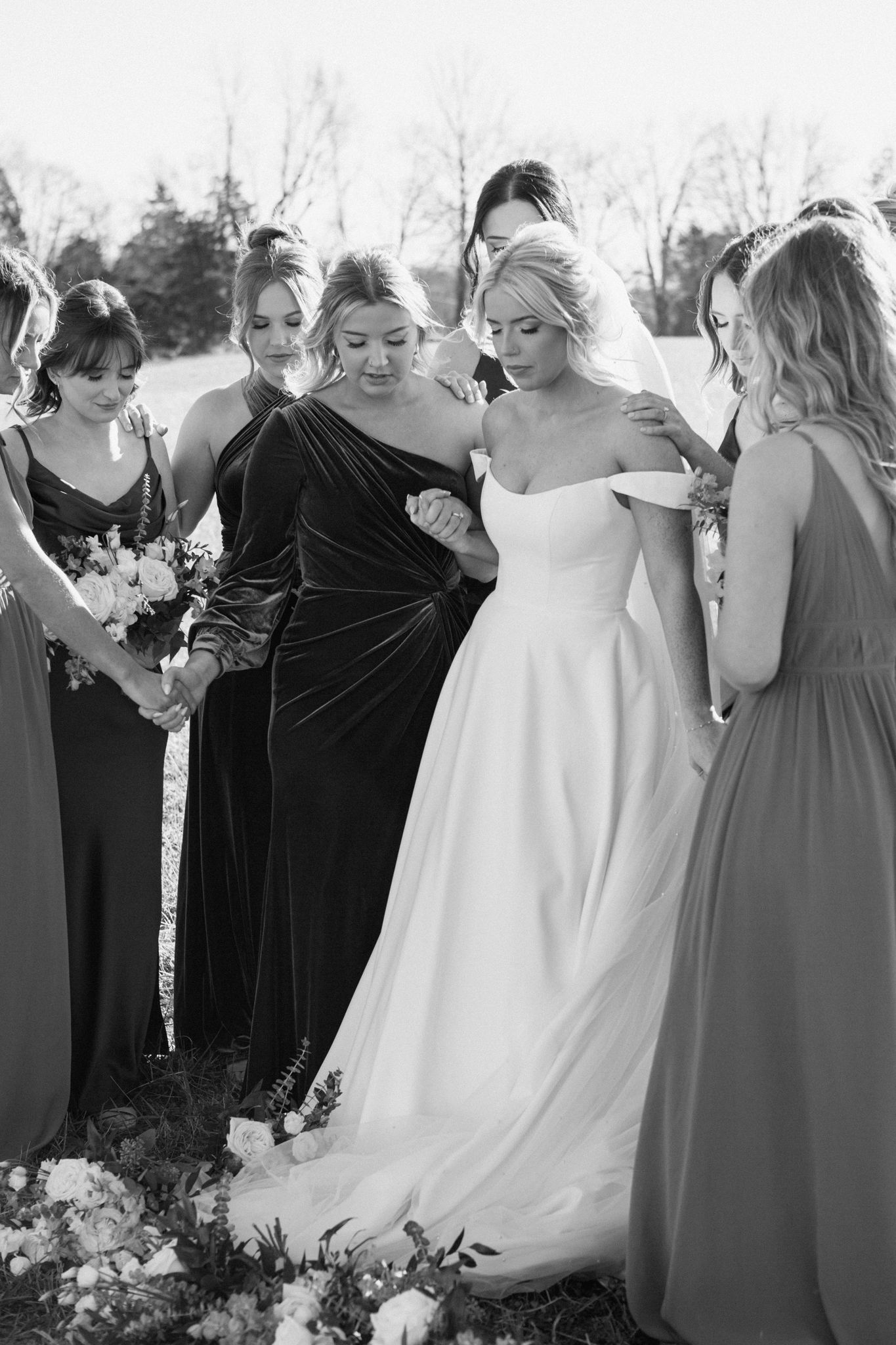 Bridesmaids praying around the bride in a touching wedding moment